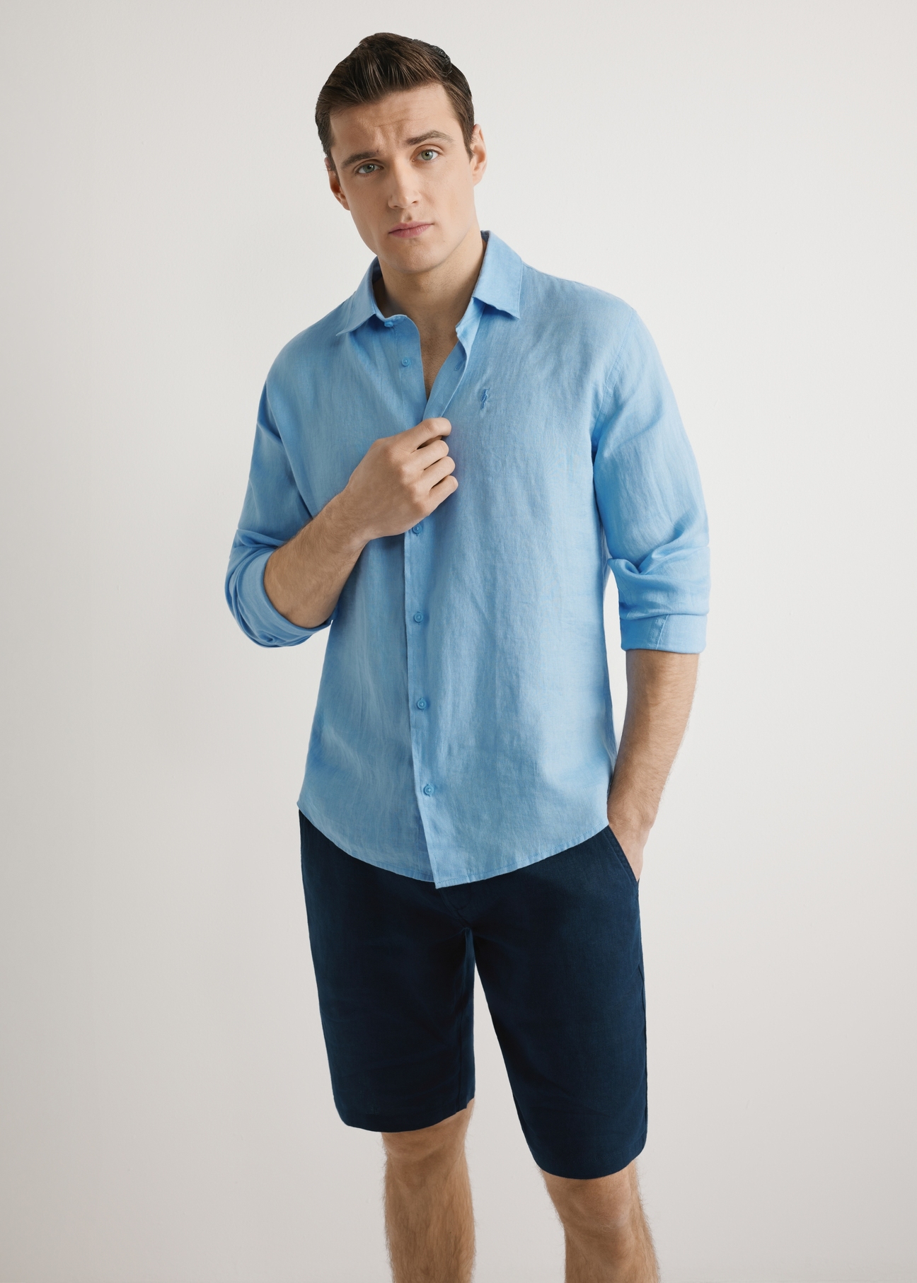 Синя чоловіча лляна сорочка KOSMT-0321A-7B(W26), вигляд виробу спереду, на моделі, на світлому фоні. Видно половину силуету.