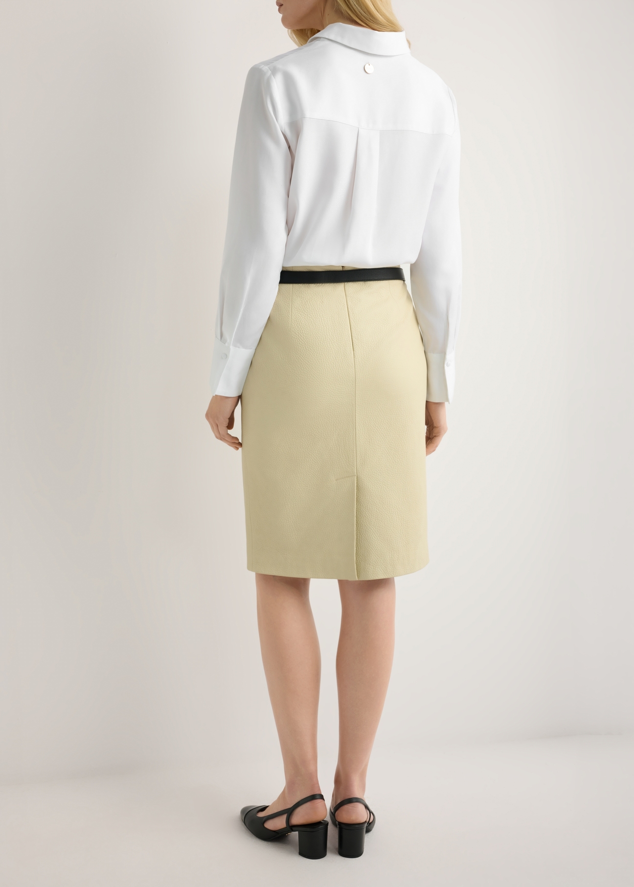 Жовта шкіряна спідниця SPCDS-0031-2A(W26), вигляд виробу ззаду на моделі. Видно половину силуету.