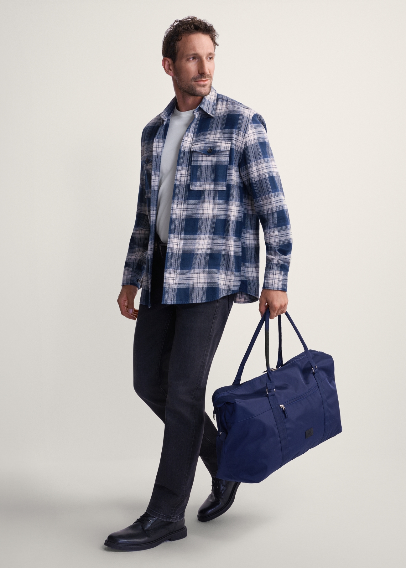 Темно-синя дорожня сумка TORMN-0382-69 (Z25), вигляд виробу в руці моделі. Видно повністю.