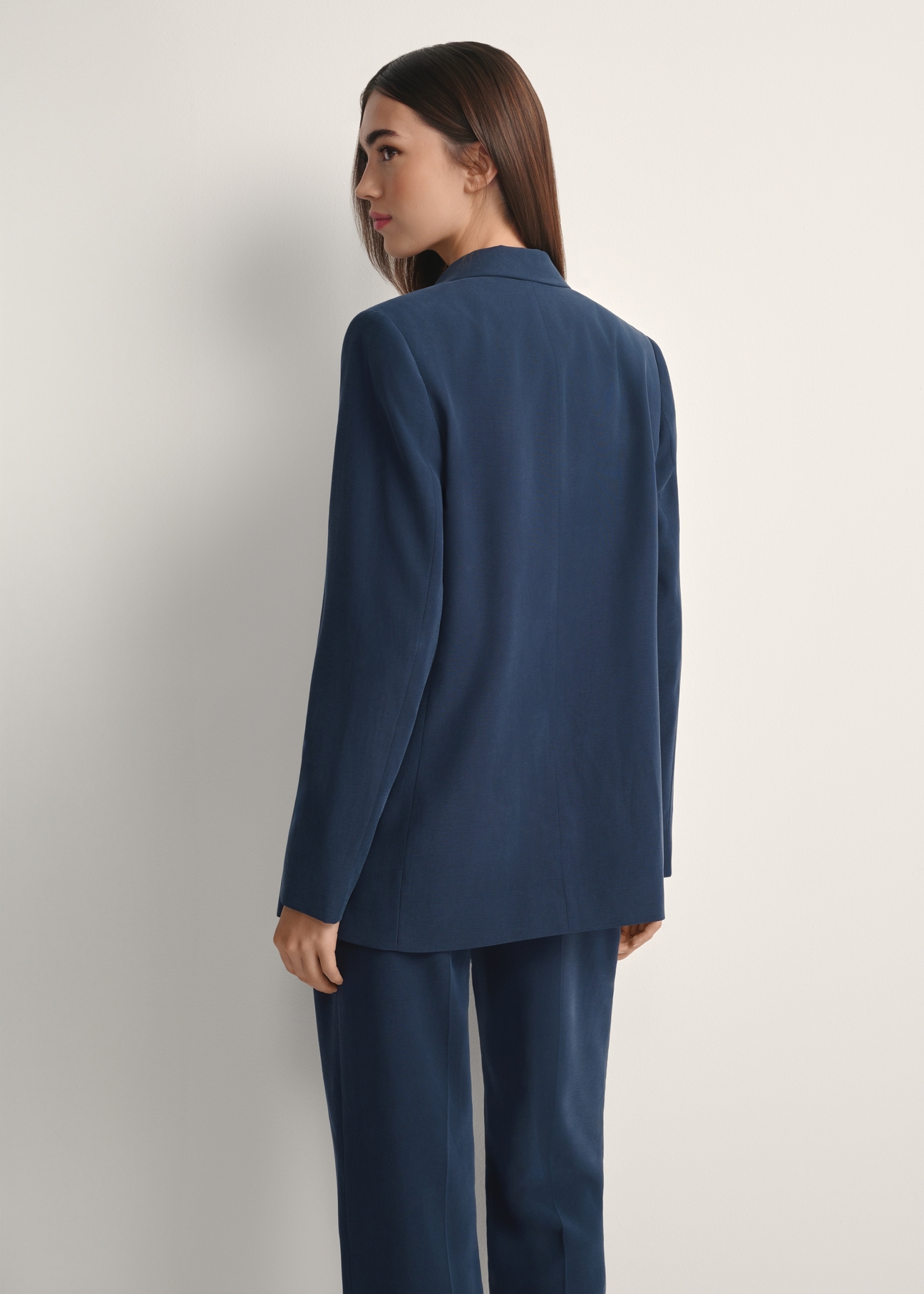 Жіночий темно-синій блейзер ZAKDT-0031A-7E(W26), вигляд виробу ззаду на моделі. Видно половину силуету.