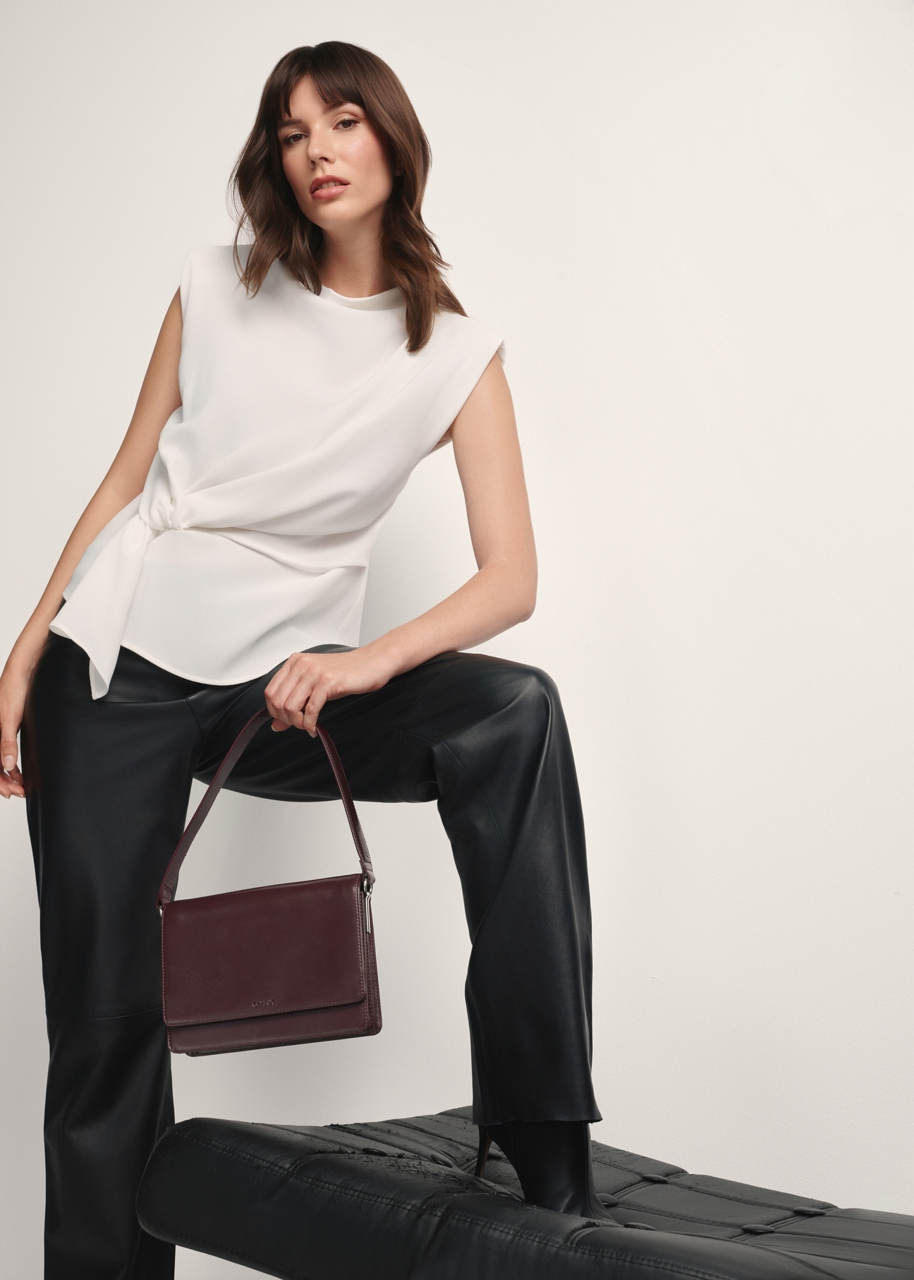 Жіноча шкіряна сумка бордового кольору TORES-1189-49(Z25), вигляд виробу в руці моделі на світлому фоні.