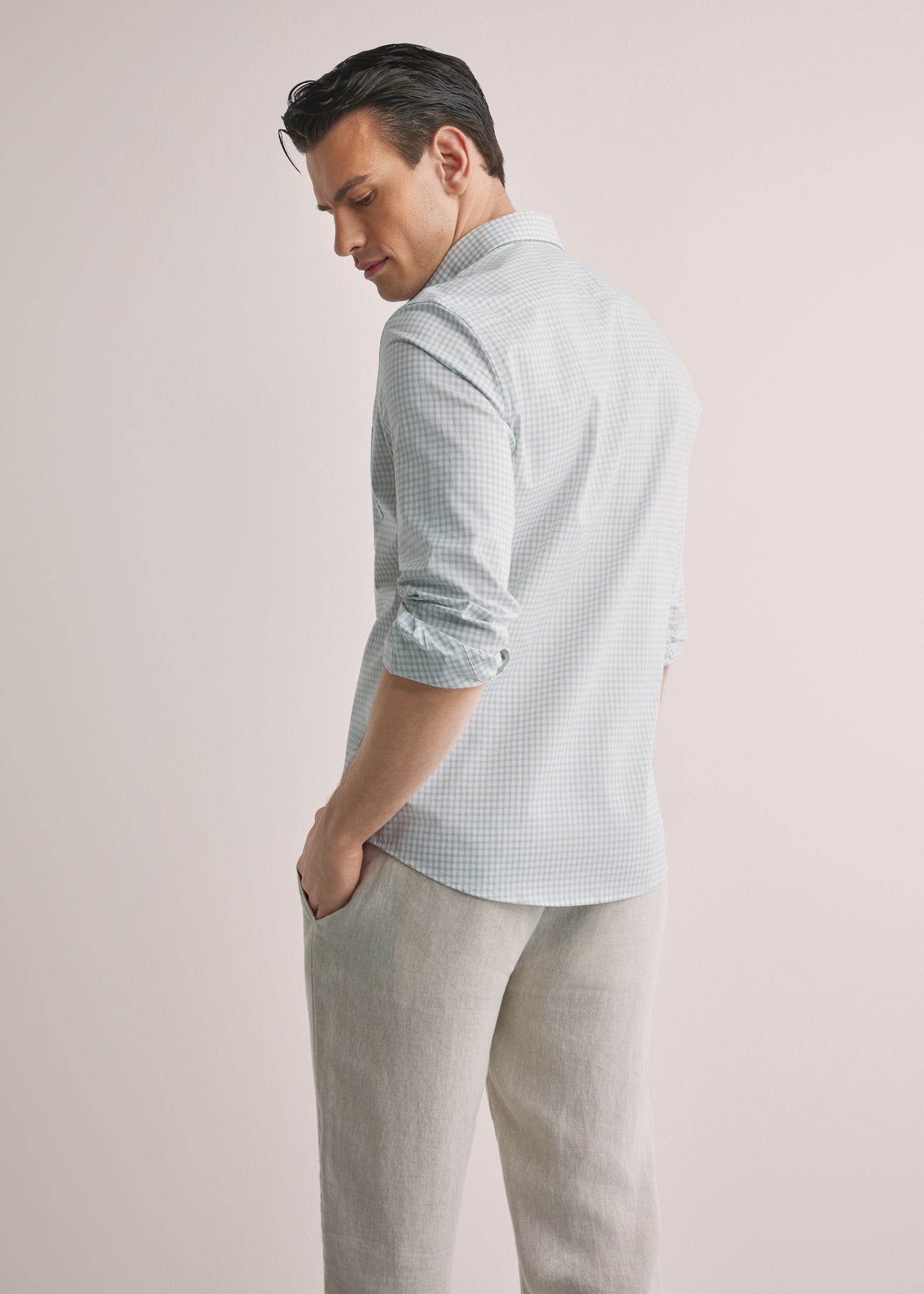 Чоловіча бавовняна сорочка в клітинку KOSMT-0277-8F(W26), вигляд виробу ззаду на моделі. Видно половину силуету.
