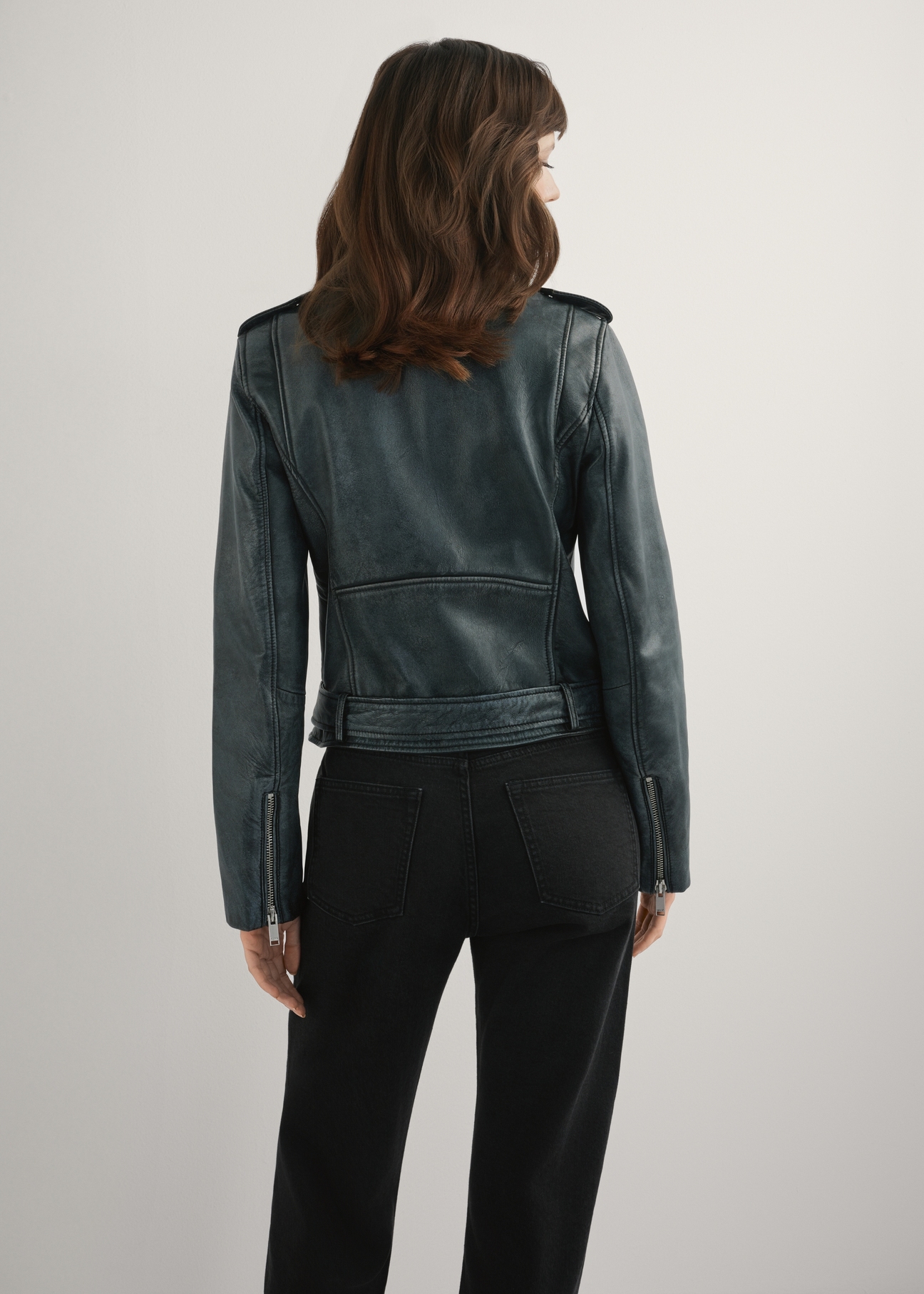 Жіноча сіра шкіряна куртка KURDS-0371-9D(W26), вигляд виробу ззаду на моделі. Видно половину силуету.