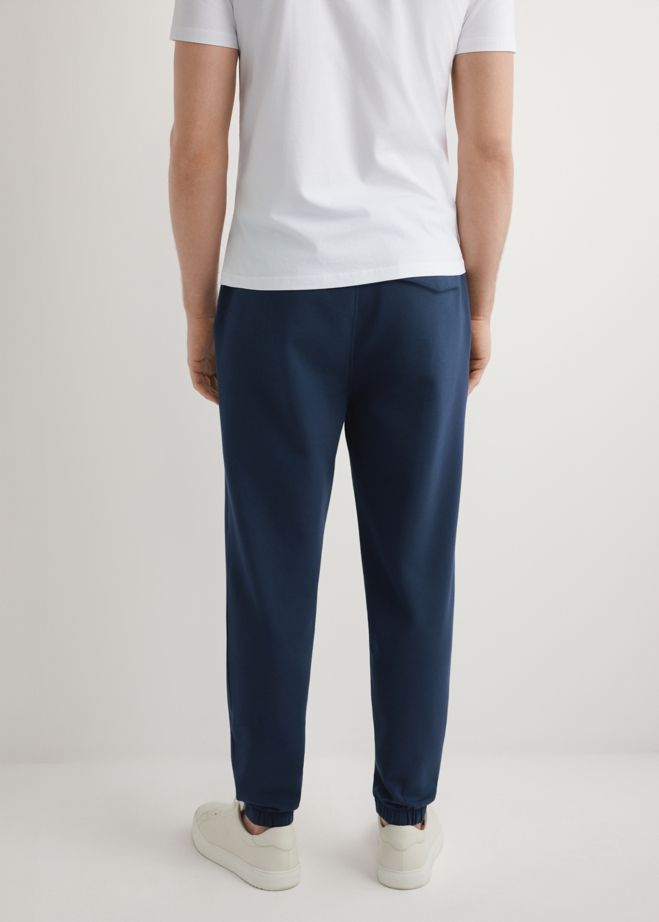 Чоловічі темно-сині спортивні штани SPOMT-0109-7E(W26), вигляд виробу зі спини на моделі. Видно половину силуету.