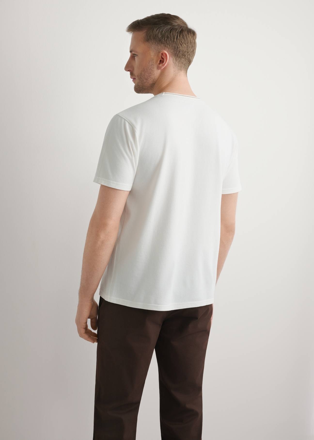 Чоловіча біла бавовняна футболка TSHMT-0150-0B(W26), вигляд виробу ззаду на моделі. Видно половину силуету.