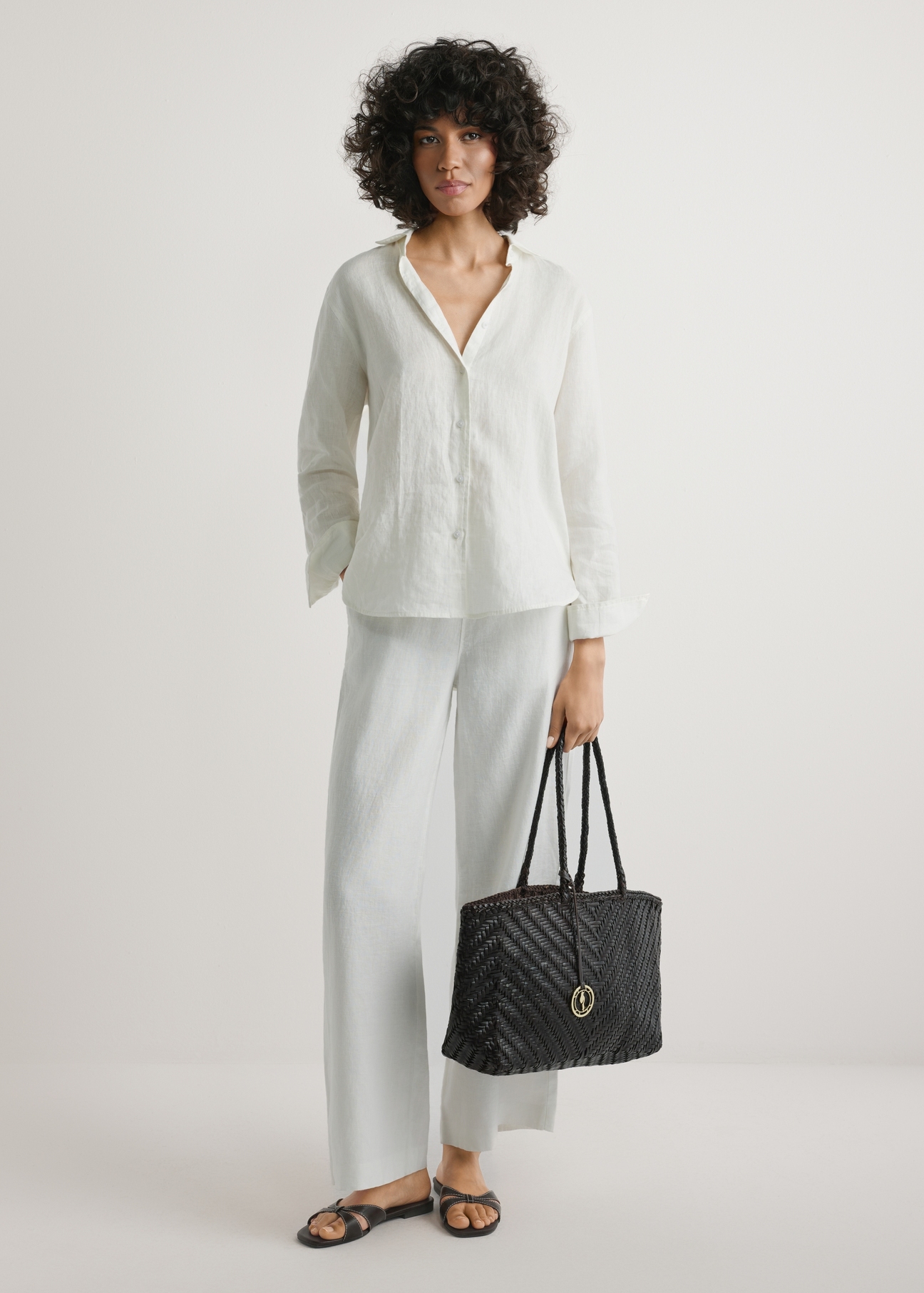 Темно-коричнева плетена жіноча сумка TORES-1301-1I(W26), вигляд виробу в руці моделі. Видно повністю.