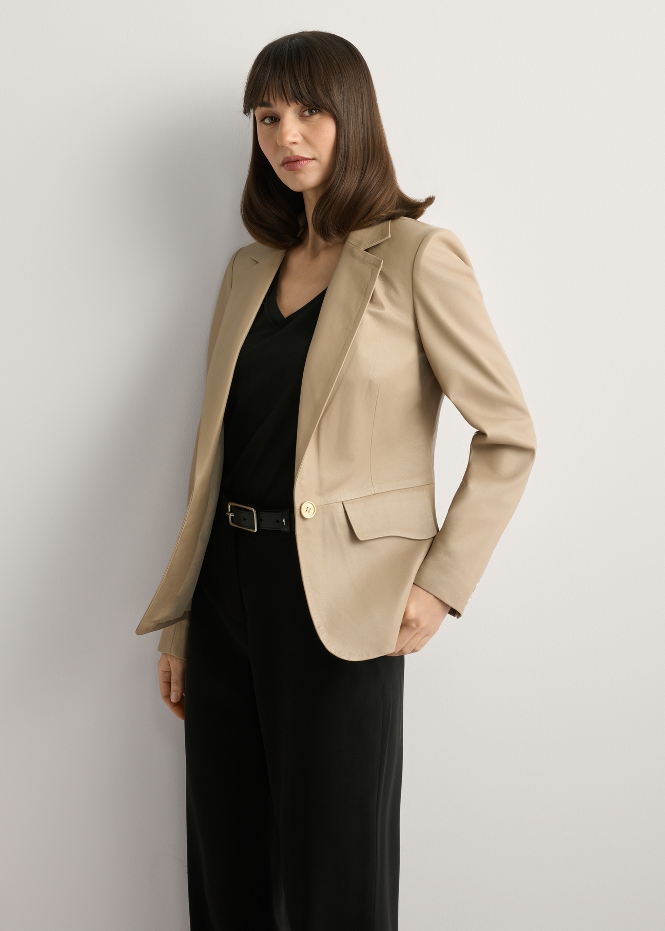 Жіноча бежева шкіряна куртка KURDS-0445-1B(W26), вигляд виробу спереду на моделі. Видно півсилуету.