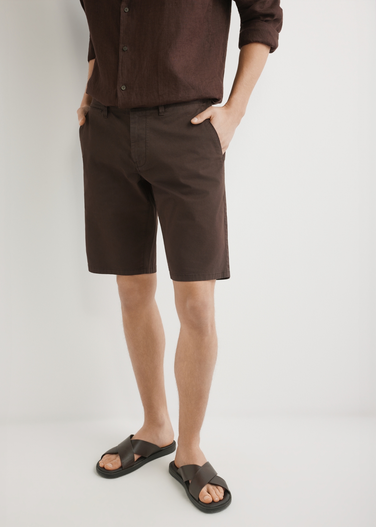 Чоловічі коричневі шорти SZOMT-0029-1I(W26), вигляд виробу спереду на моделі. Видно половину силуету.