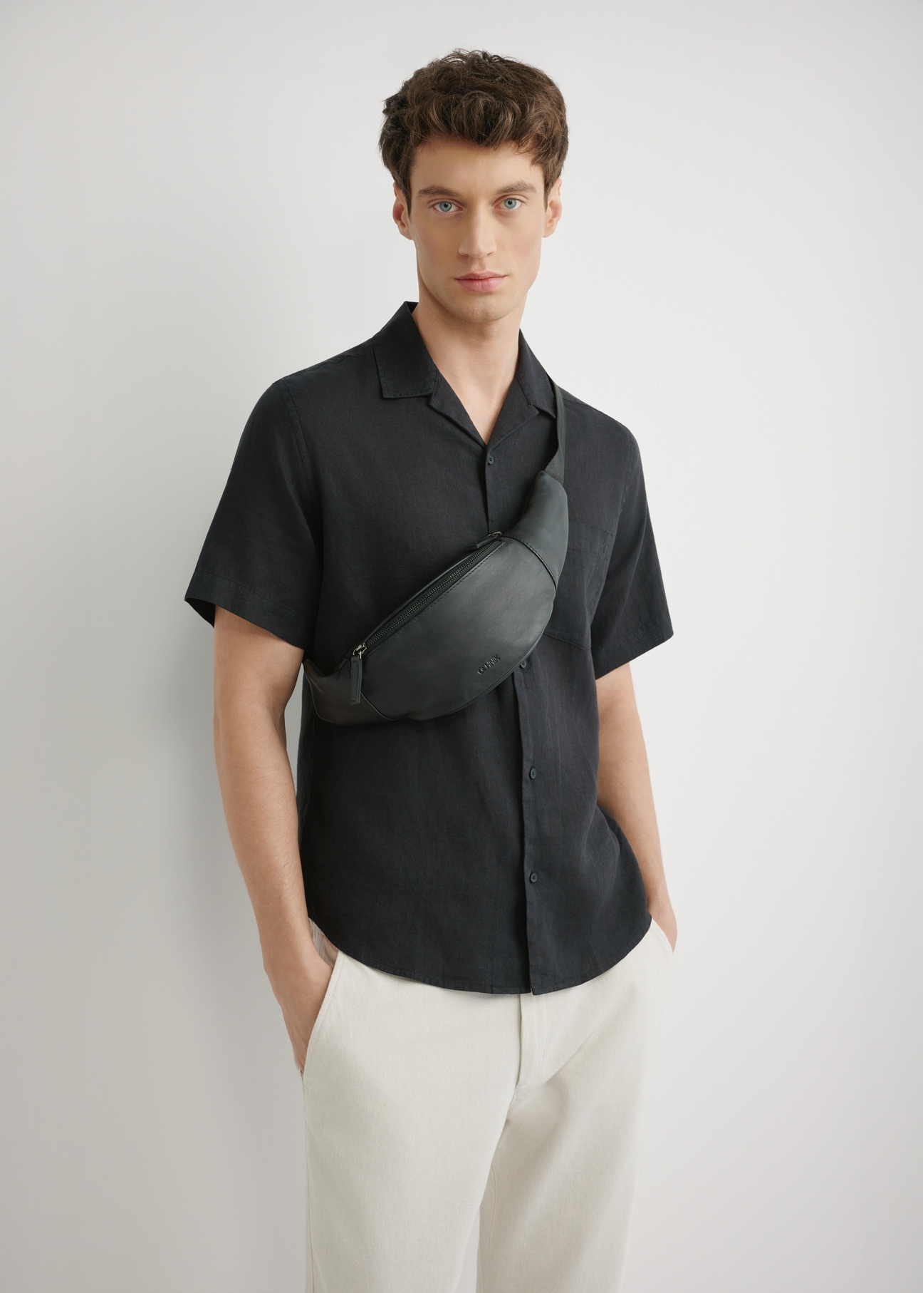 Чоловіча чорна шкіряна поясна сумка TORMS-0497-99(W26), вигляд виробу спереду на силуеті моделі.