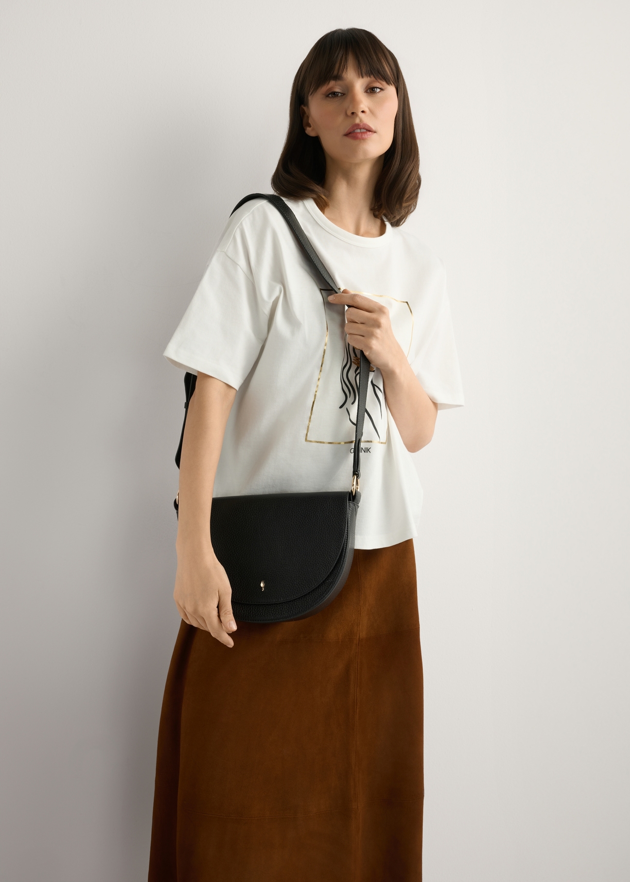 Чорна шкіряна жіноча сумка TORES-0895D-99(Z25), вигляд виробу на плечі моделі. Видно половину силуету.