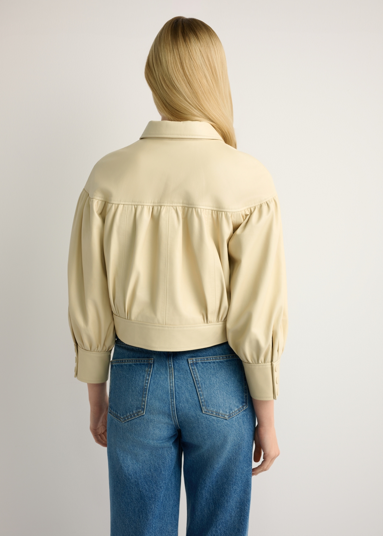 Світло-жовта жіноча шкіряна куртка KURDS-0574-2A(W26), вигляд виробу ззаду на моделі. Видно половину силуету.