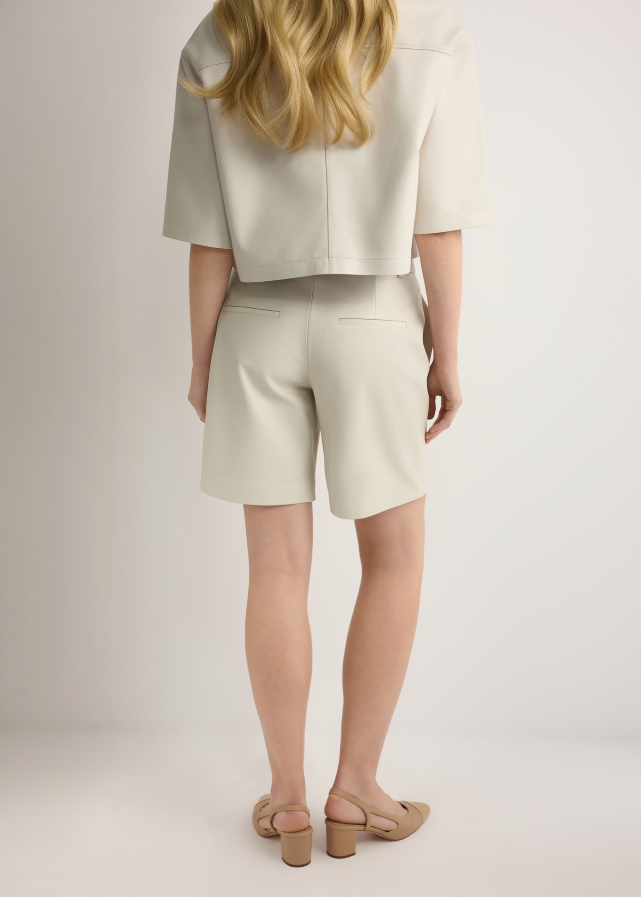 Жіночі кремові шкіряні шорти SPODS-0047-0B(W26), вигляд виробу ззаду на моделі. Видно половину силуету.