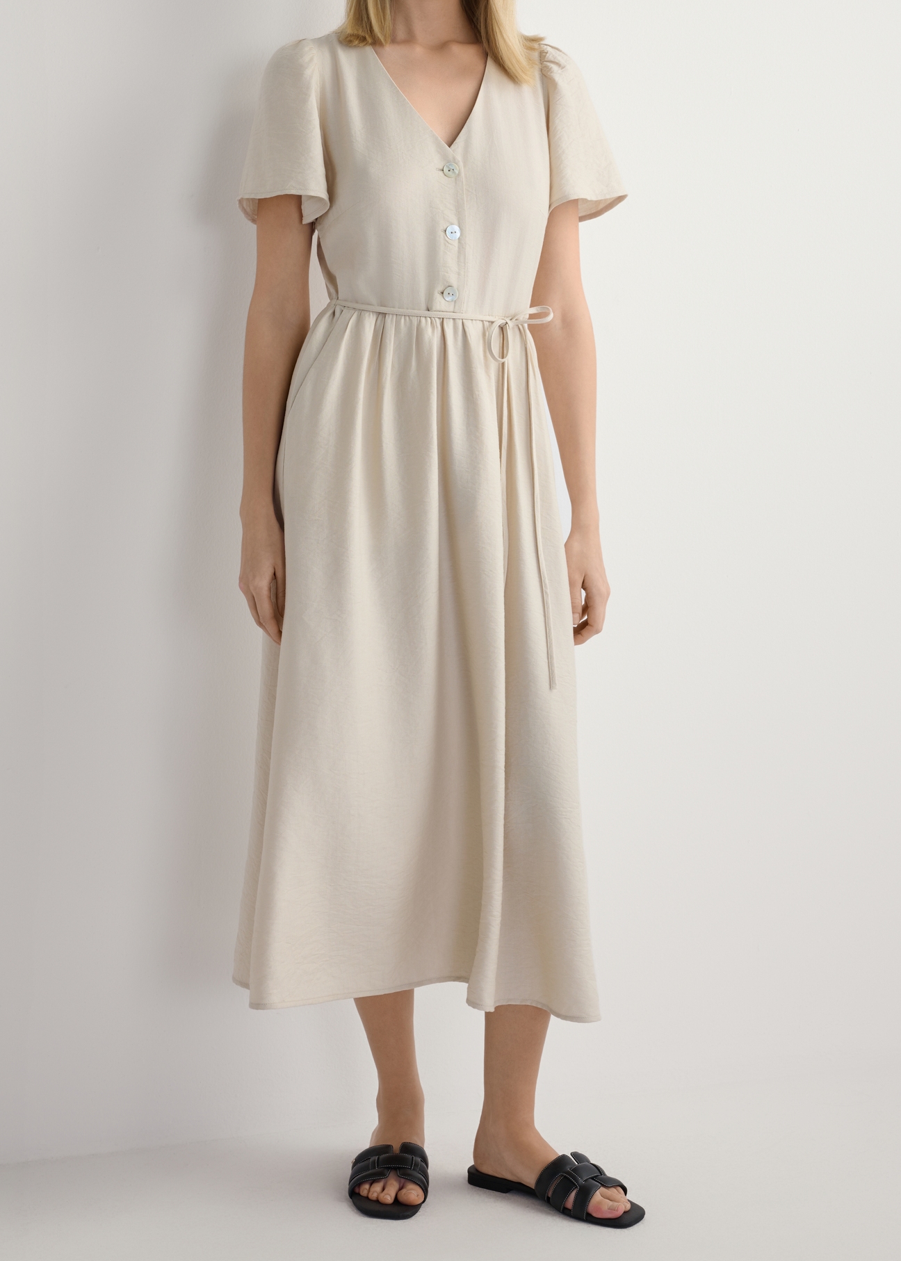 Жіночі чорні шкіряні плетені шльопанці BUTYD-1225-99(W26), вигляд виробу спереду на ногах моделі, на білому фоні. Видно половину силуету.