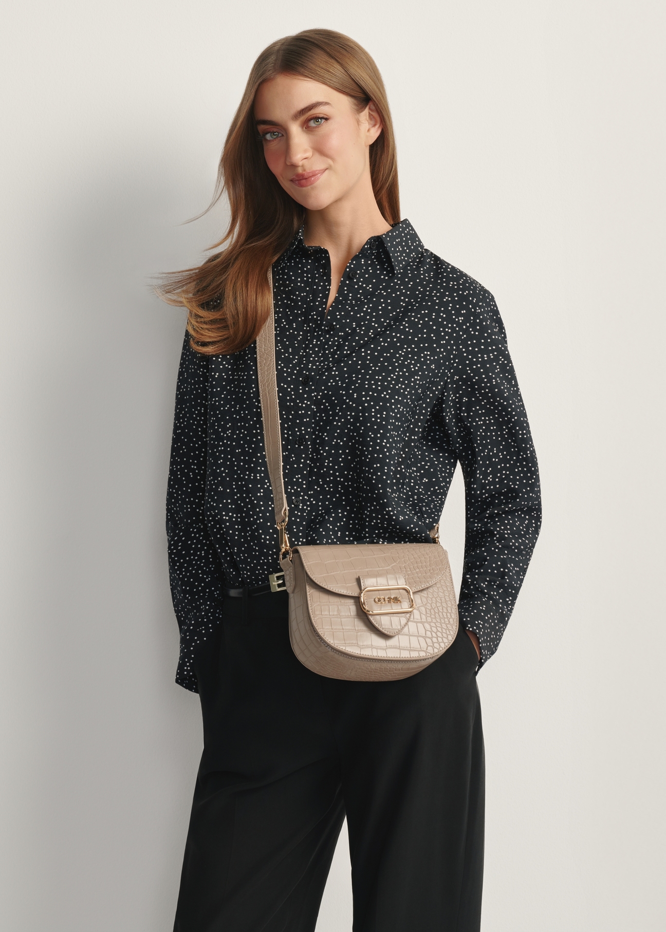 Бежева жіноча сумка-месенджер з крокодилової шкіри TOREC-0880-1D(W26), вигляд виробу на плечі моделі. Видно половину силуету.