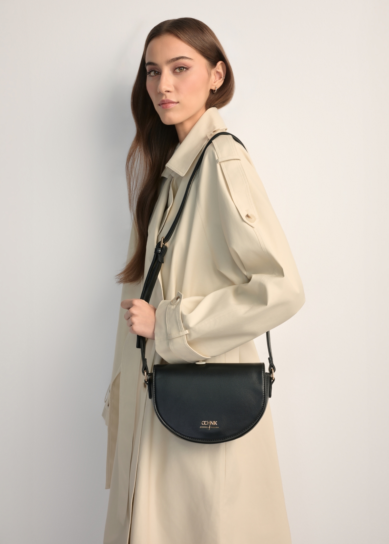 Чорна напівкругла жіноча сумка-месенджер TOREC-1184-99(W26), вигляд виробу на плечі моделі. Видно половину силуету.