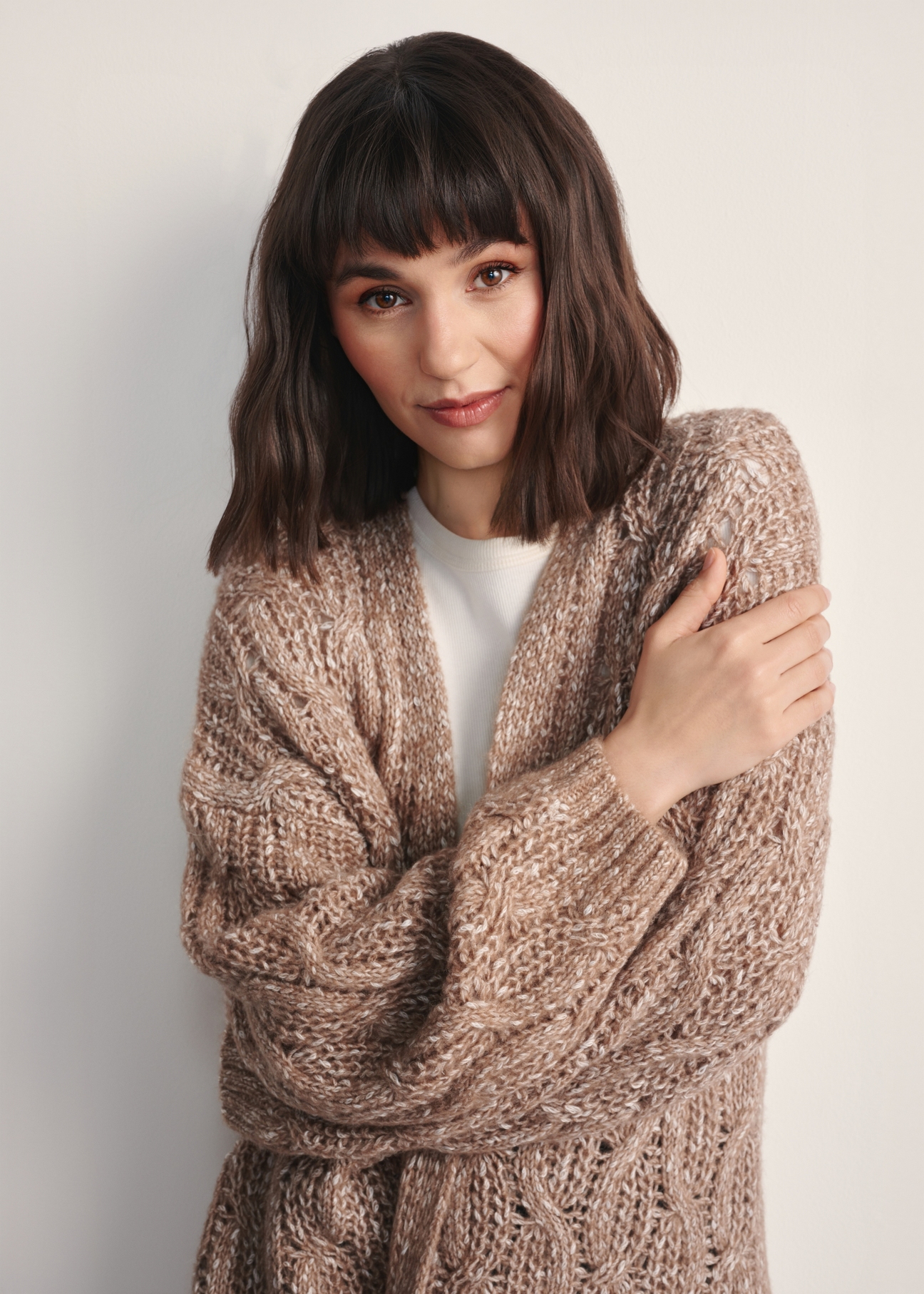 Жіночий довгий кардиган кольору верблюжої шкіри KARDT-0055-24(Z25), крупний план деталі виробу на моделі. Видно половину силуету.