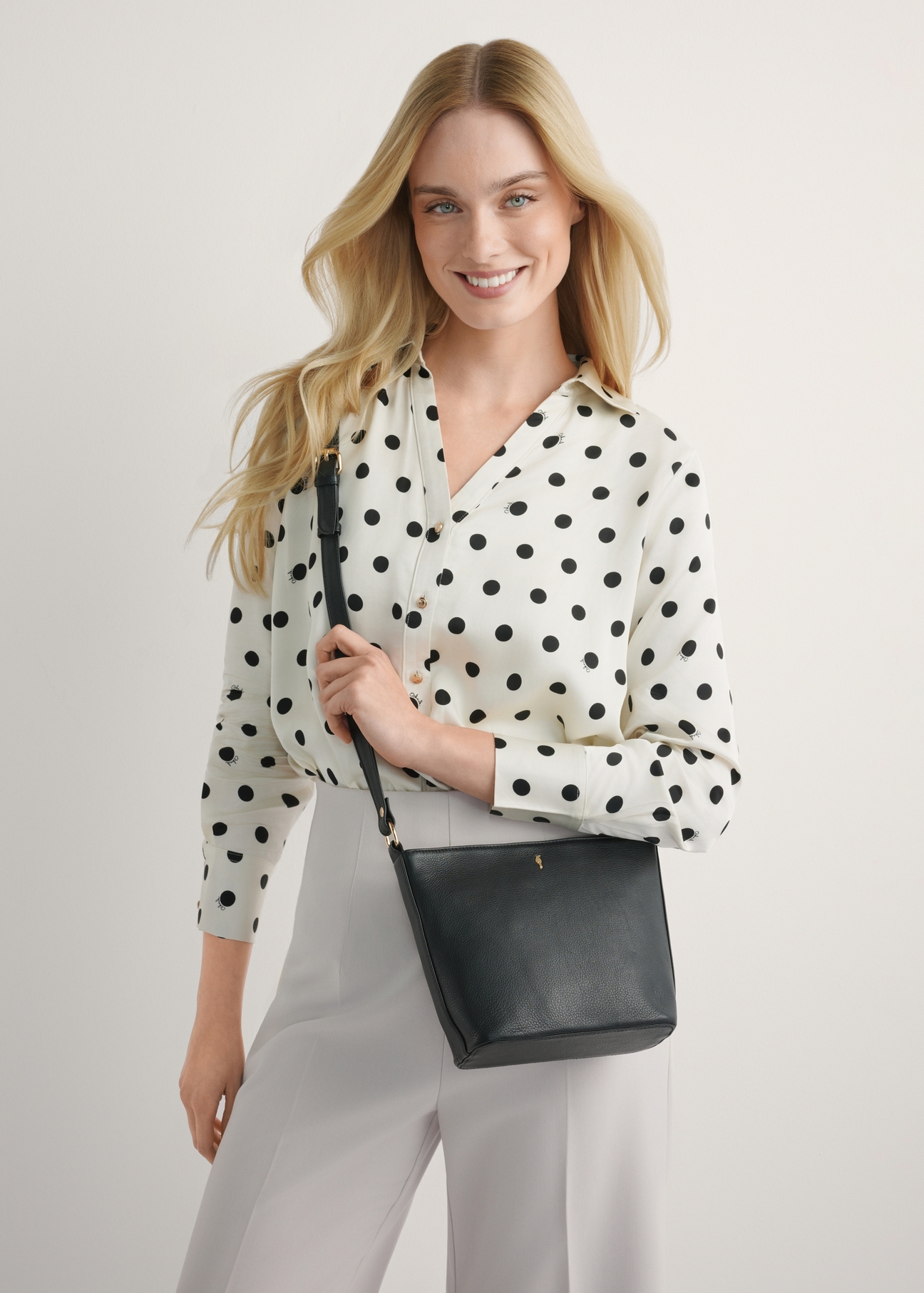 Чорна шкіряна сумка через плече TORES-1280-99(W26), вигляд виробу на силуеті моделі, на світлому фоні.