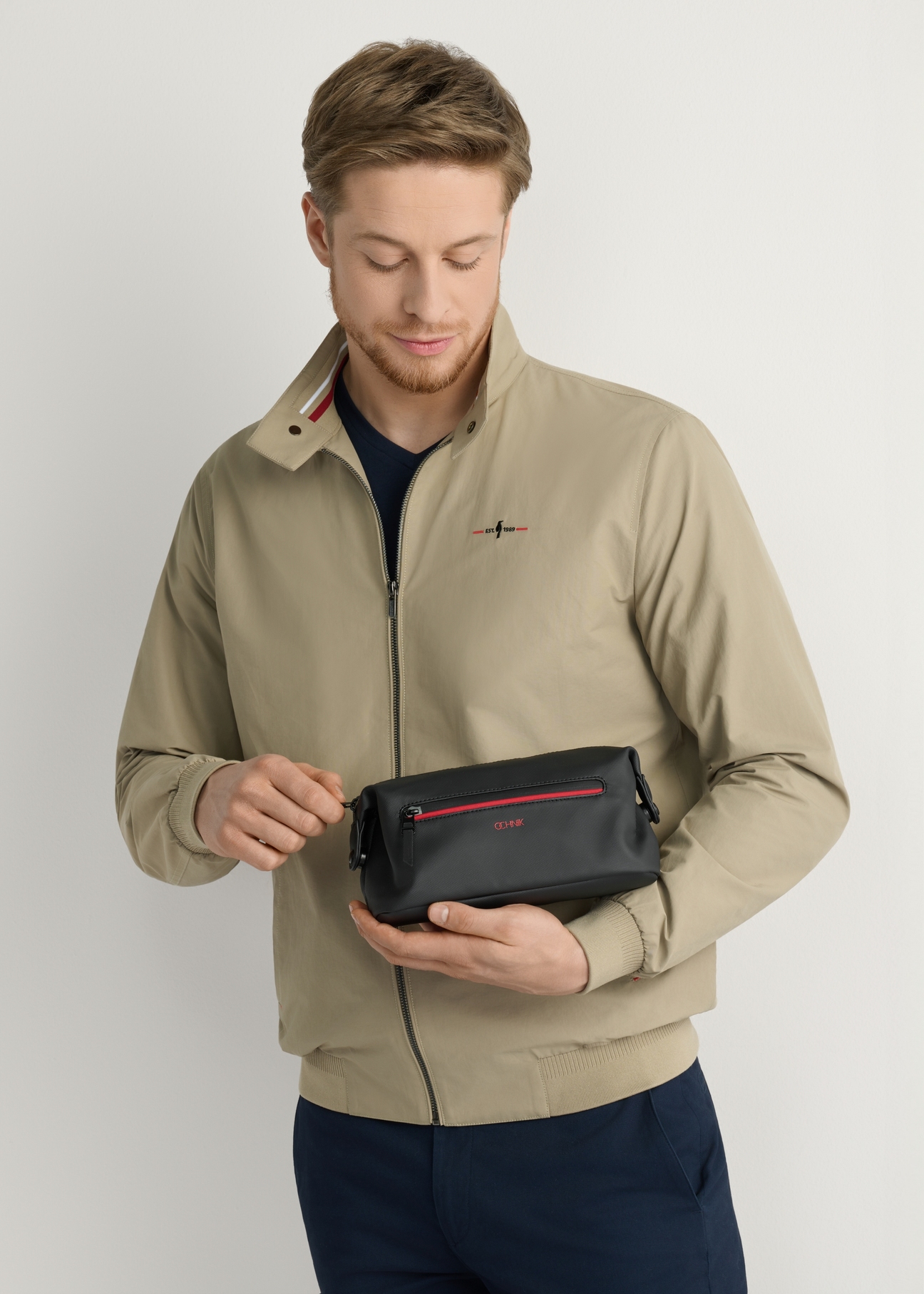 Чорна чоловіча косметичка TORMN-0397-9J(W26), вигляд виробу в руці моделі, на світлому фоні.