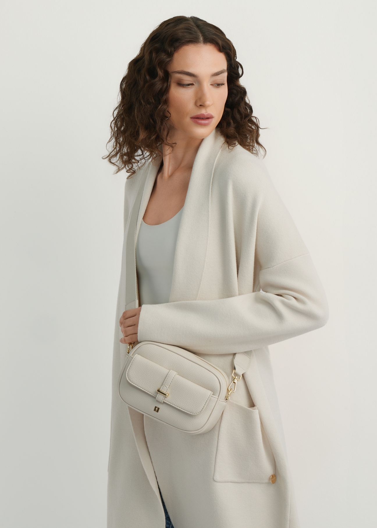 Маленька кремова жіноча сумочка TOREC-1174-0B(W26), вигляд виробу на плечі моделі. Видно половину силуету.