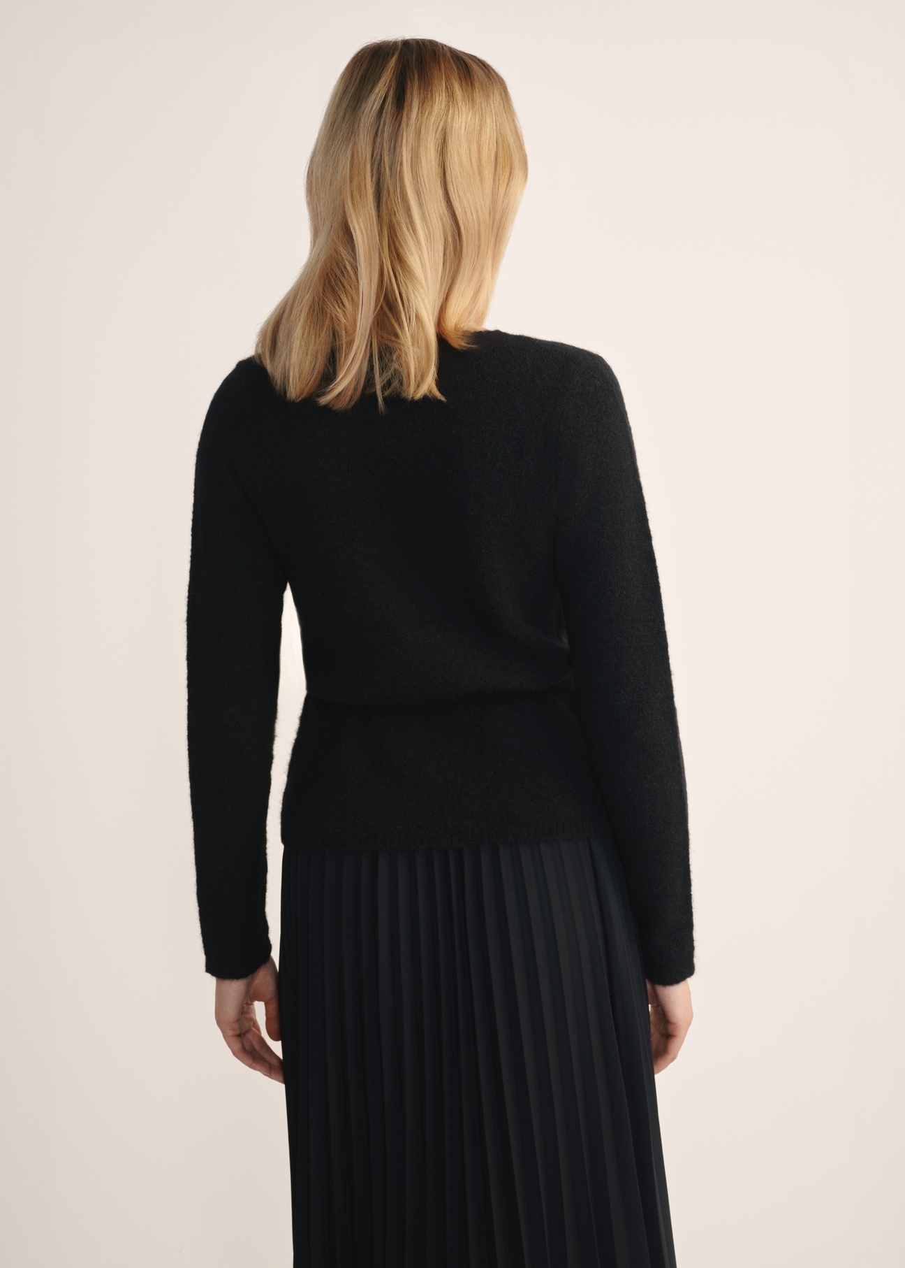 Чорний жіночий светр із зав'язкою SWEDT-0234-99(Z25), вигляд виробу ззаду на моделі. Видно половину силуету.