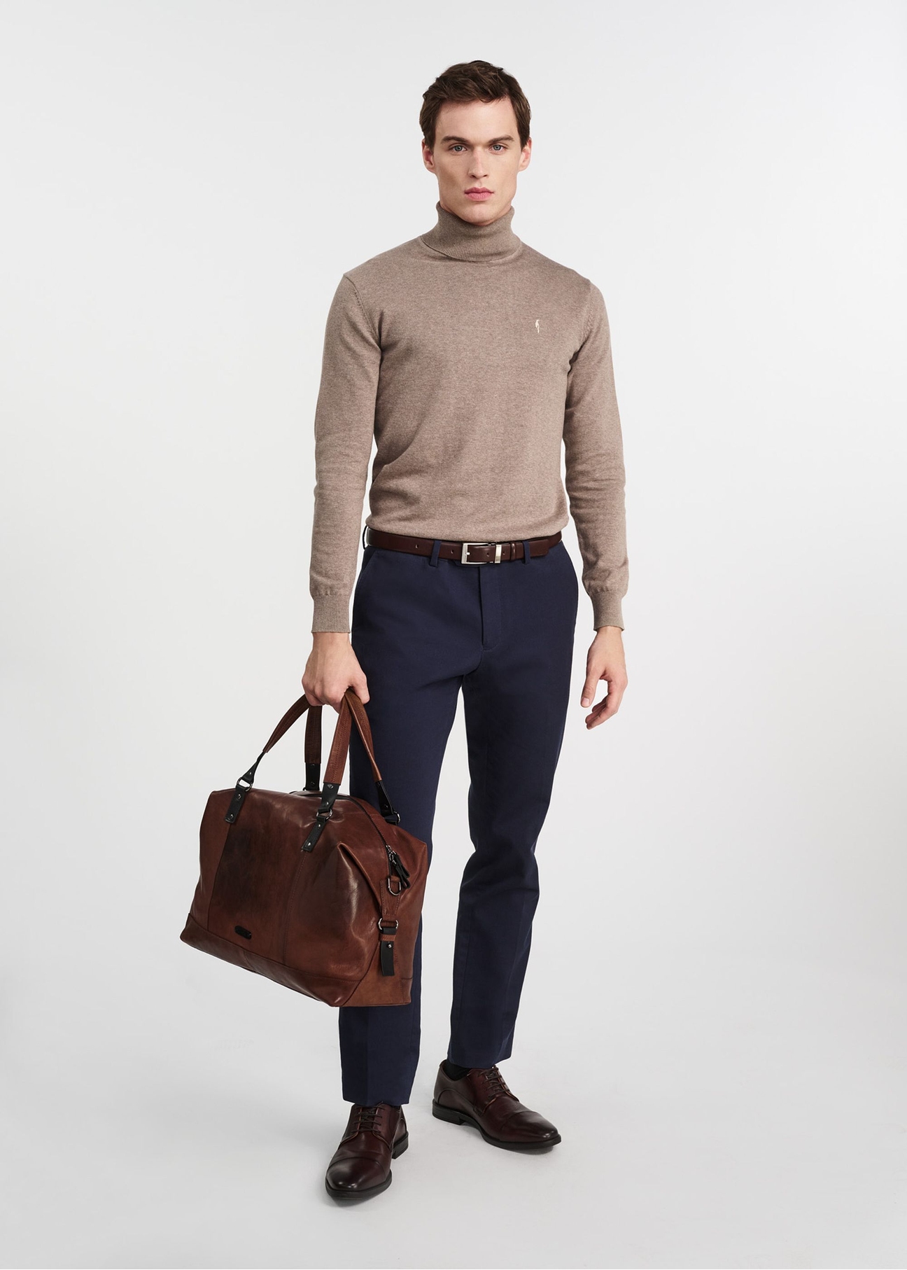 Коричнева шкіряна велика чоловіча сумка TORMS-0103-1H(W26), вигляд виробу в руці моделі, на світлому фоні.