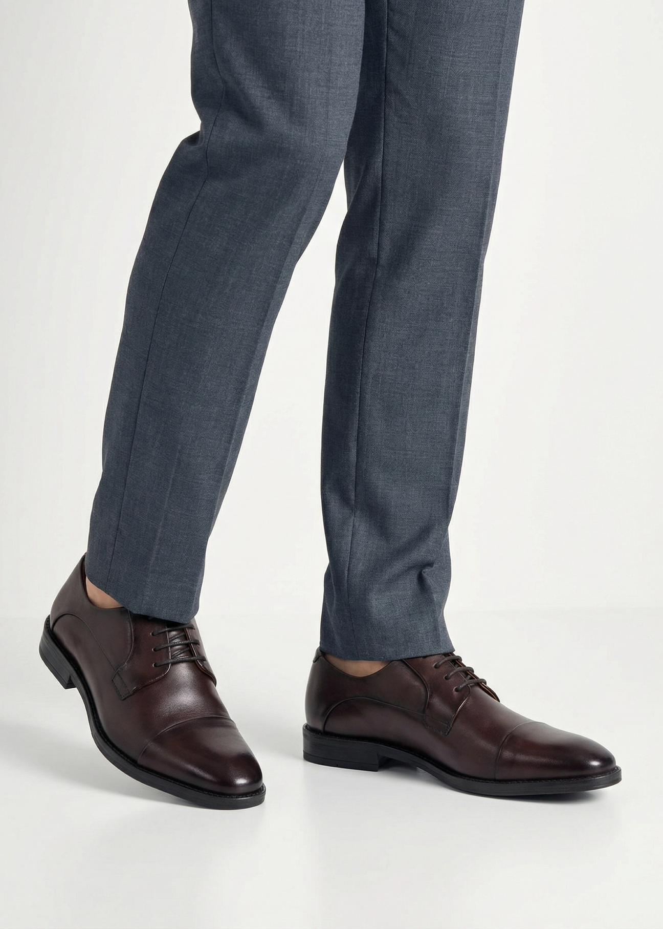 Чоловіче коричневе шкіряне взуття BUTYM-0483-1I(W26), вигляд виробу на ногах моделі, на світлому фоні.