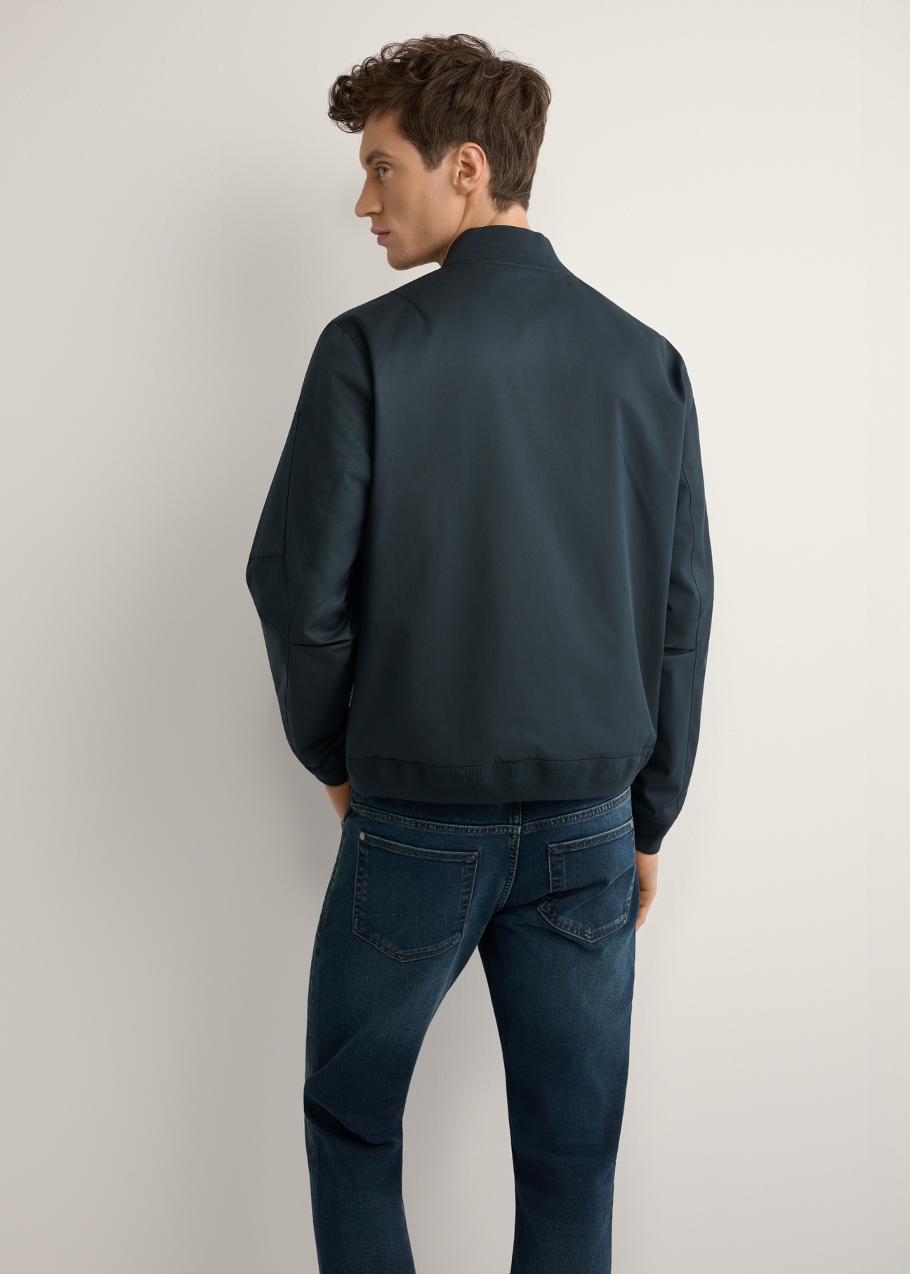 Чоловіча темно-синя перехідна куртка KURMT-0403-7D(W26), вигляд виробу зі спини на моделі. Видно половину силуету.
