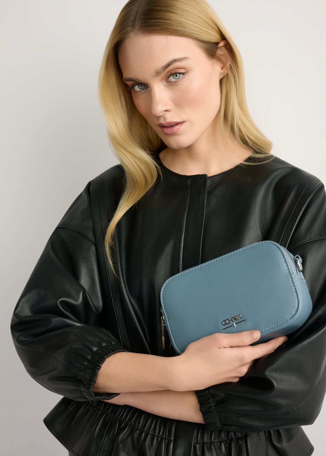 Синя маленька жіноча сумочка TOREC-1172-7C(W26), вигляд виробу в руці моделі. Видно половину силуету.