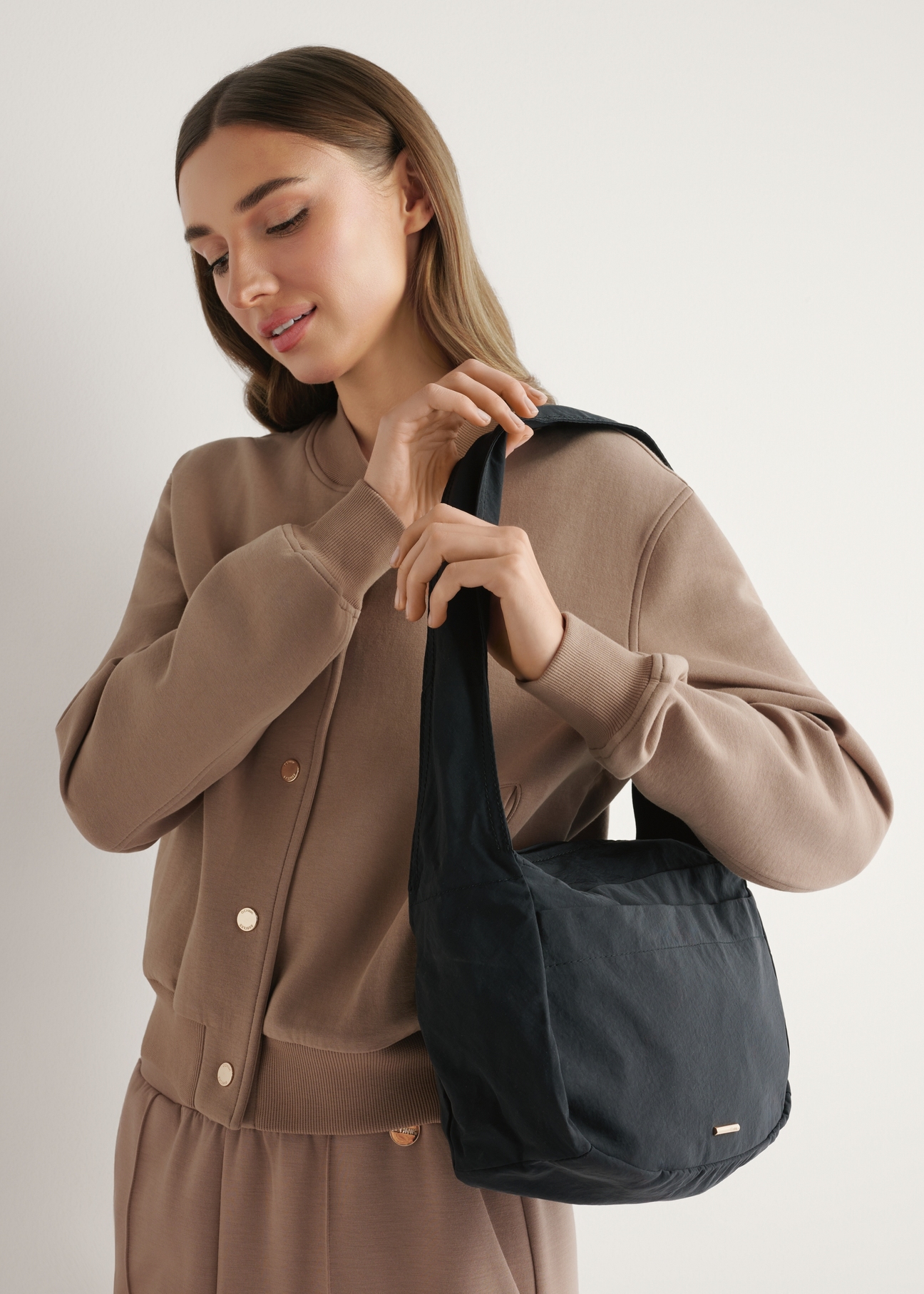 Чорна нейлонова жіноча сумка TOREN-0338-99(W26), діагональний вигляд виробу на плечі моделі.