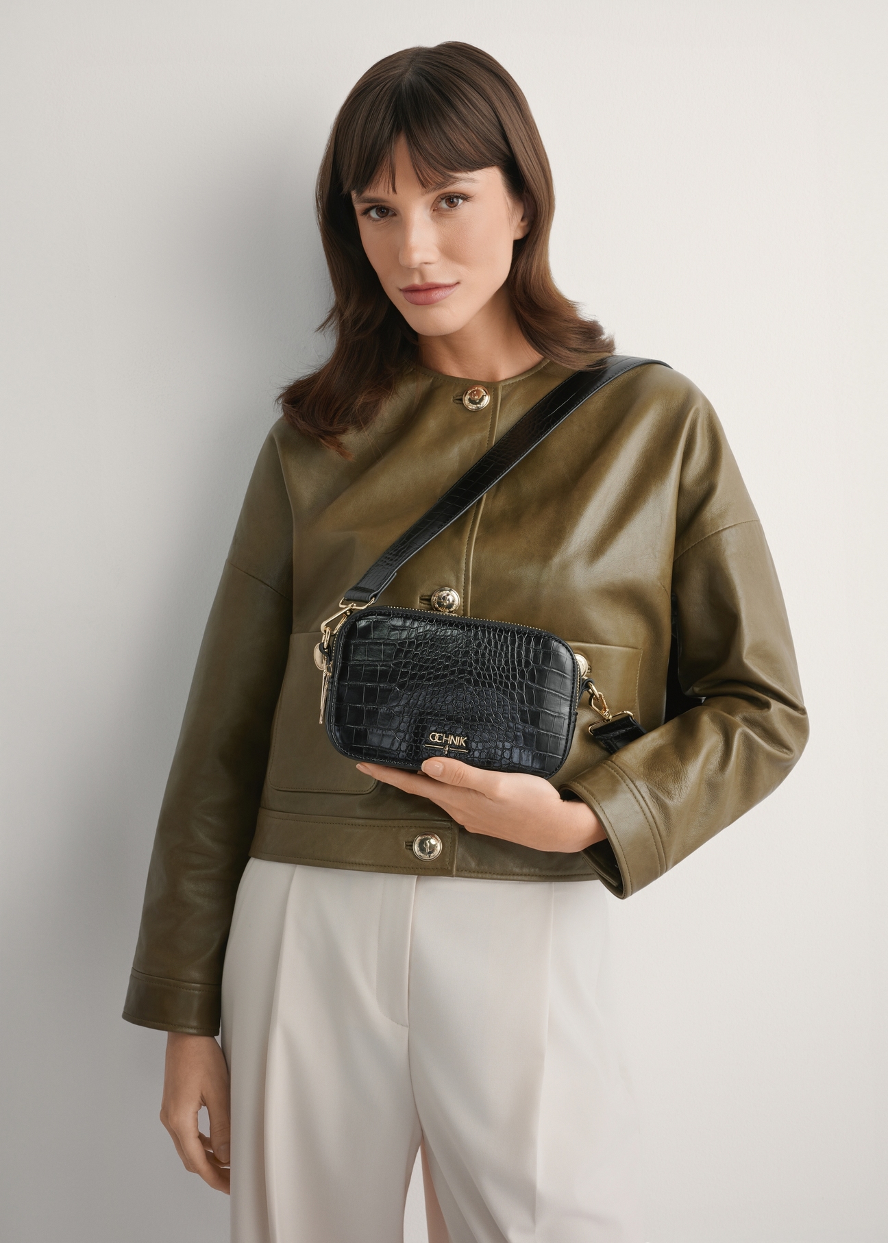 Чорна маленька жіноча сумочка з крокоподібної шкіри TOREC-1172-9G(W26), вигляд виробу спереду на силуеті моделі.