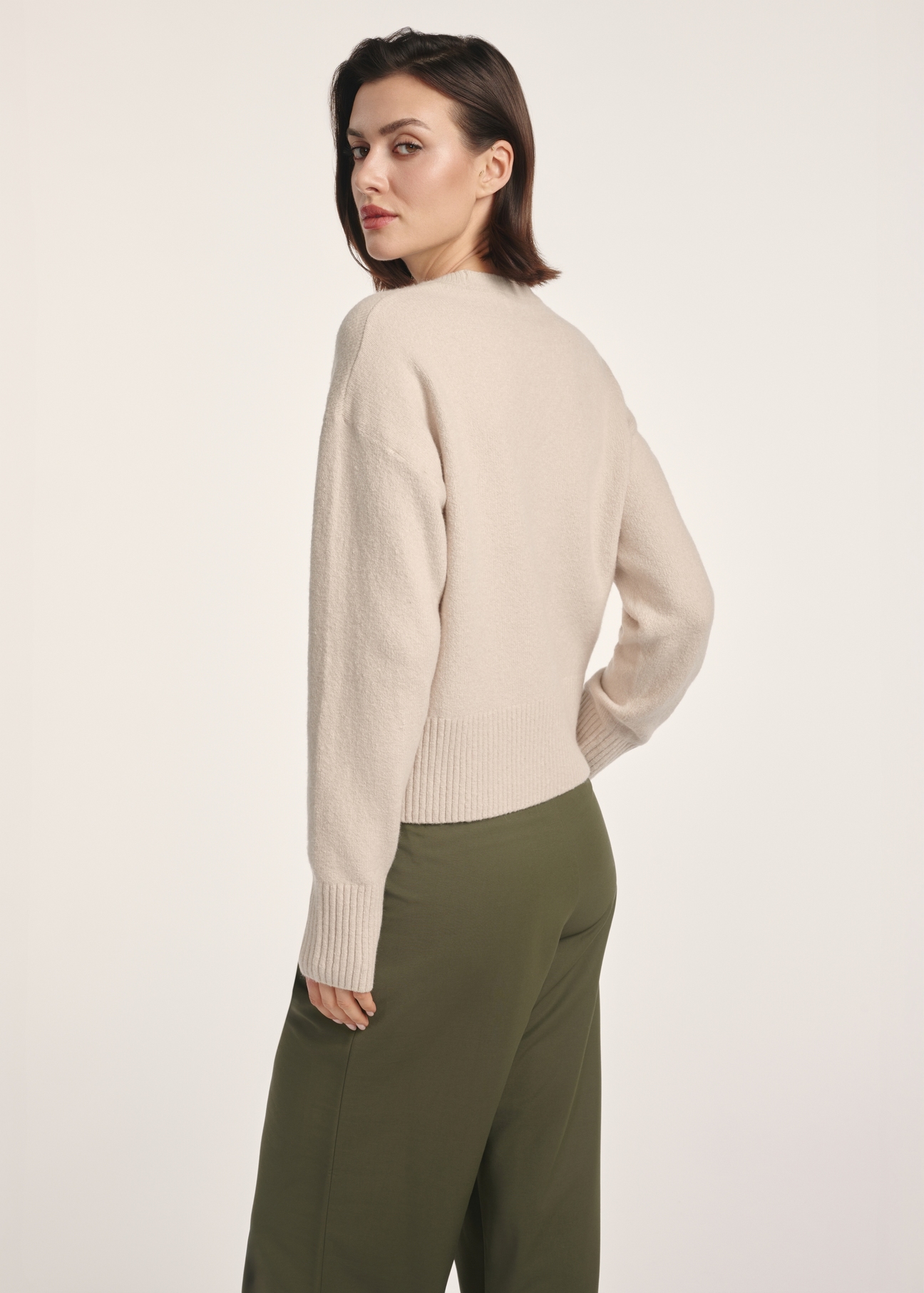 Бежевий жіночий светр SWEDT-0242-80(Z25), вигляд виробу зі спини на моделі. Видно половину силуету.