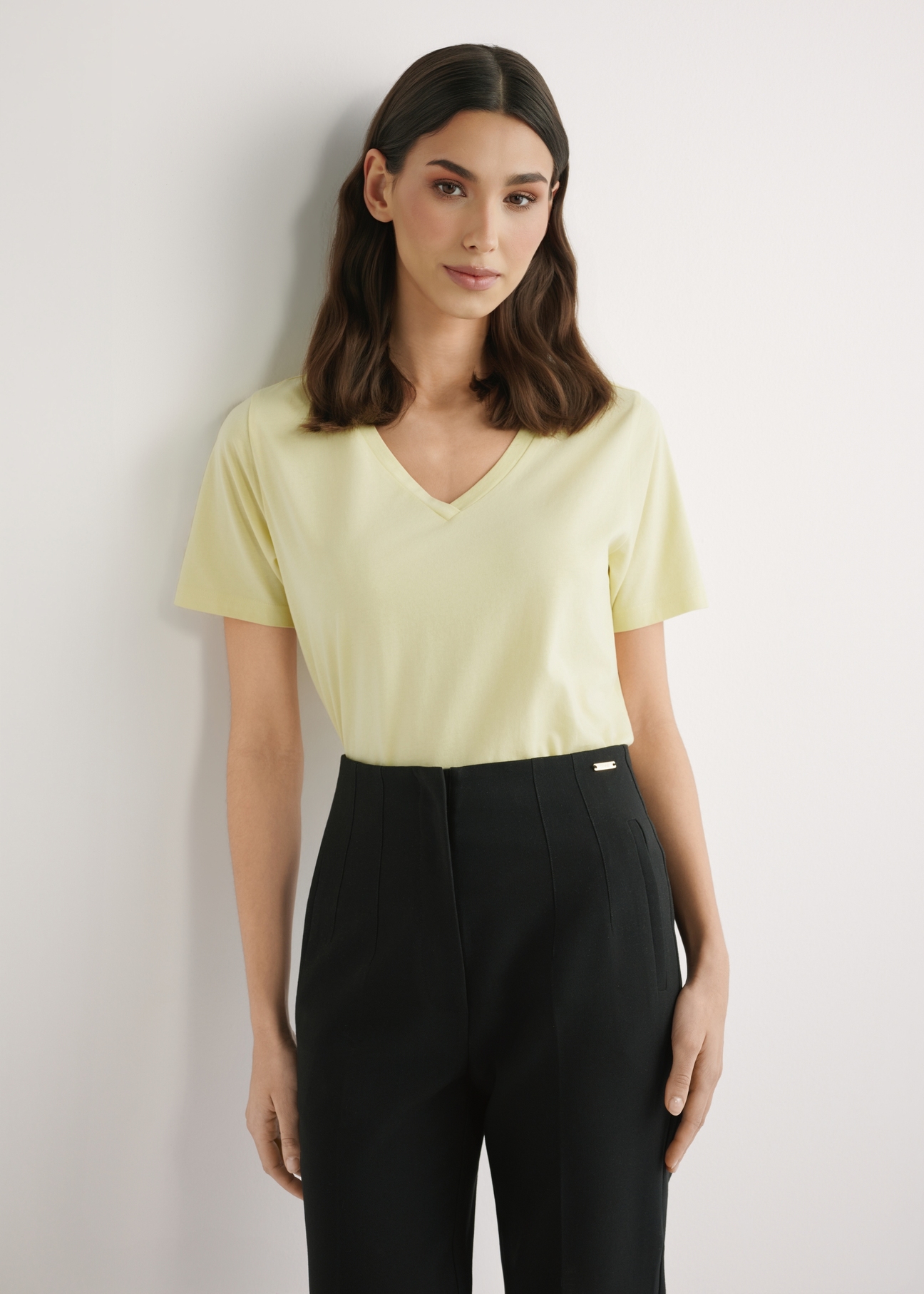 Світло-жовта жіноча базова футболка TSHDT-0120-2A(W26), вигляд виробу спереду на моделі. Видно половину силуету.