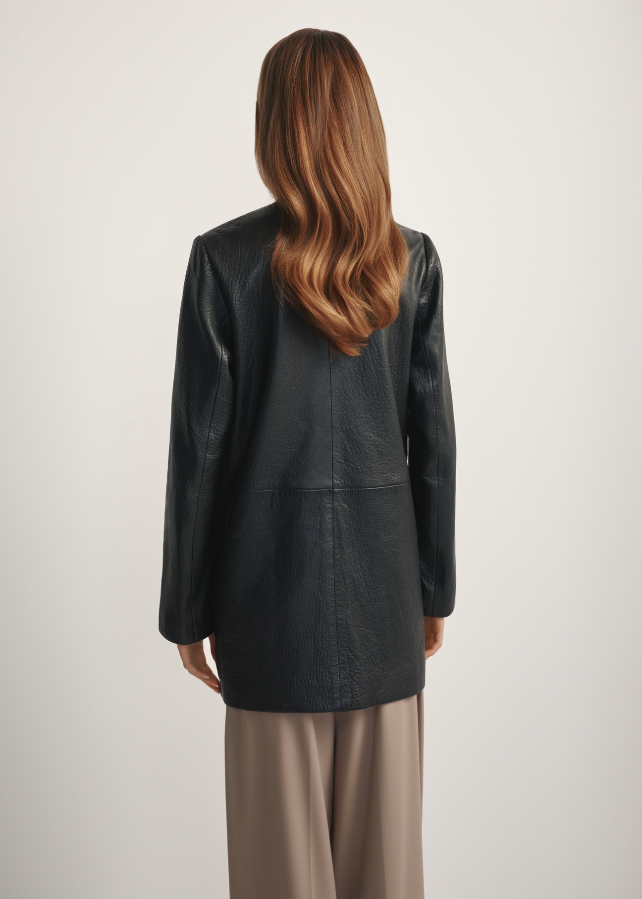 Жіноча чорна шкіряна куртка KURDS-0583-99(W26), вигляд виробу ззаду на моделі. Видно половину силуету.