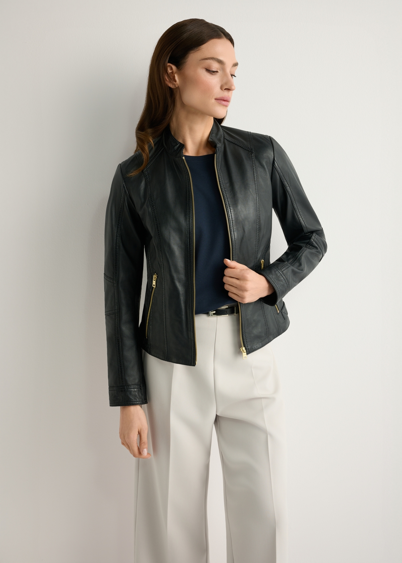 Жіноча чорна шкіряна куртка KURDS-0602-99(W26), вигляд виробу спереду на моделі. Видно половину силуету.