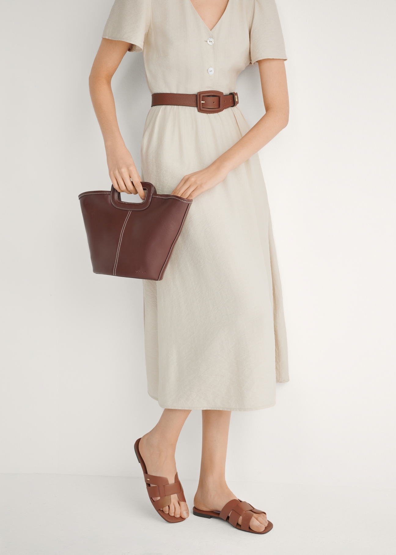 Жіночі шльопанці з плетеною основою кольору верблюжого шльопанці BUTYD-0904D-1D(W26), вигляд виробу збоку на ногах моделі.