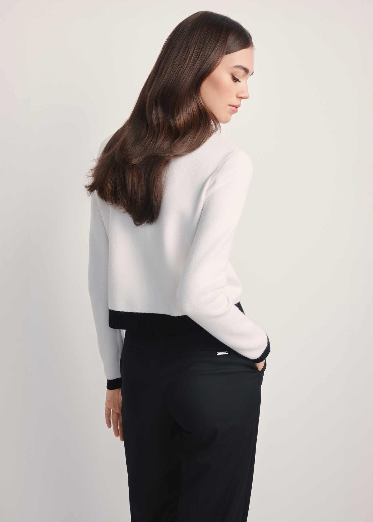 Жіночий білий кардиган KARDT-0053-12(Z25), вигляд виробу ззаду на моделі. Видно половину силуету.