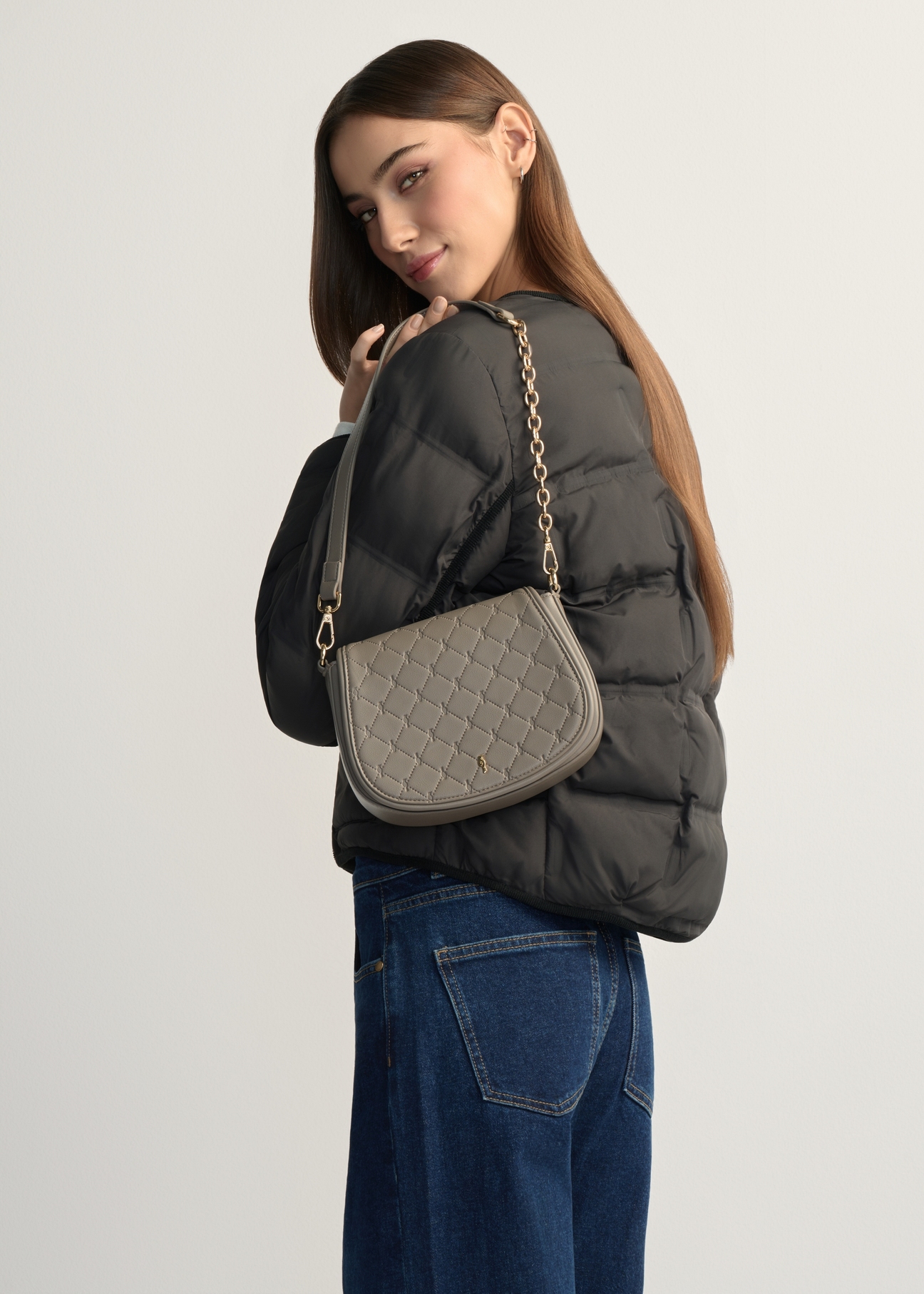 Світло-коричнева жіноча сумка-месенджер TOREC-1179-1K(W26), вигляд виробу на плечі моделі. Видно половину силуету.