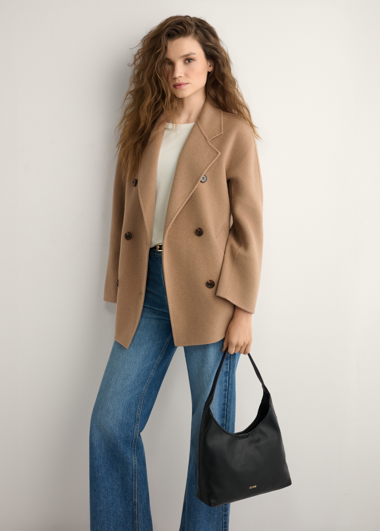 Чорна жіноча сумка середнього розміру TOREC-1200-99(W26), вигляд виробу в руці моделі. Видно половину силуету.