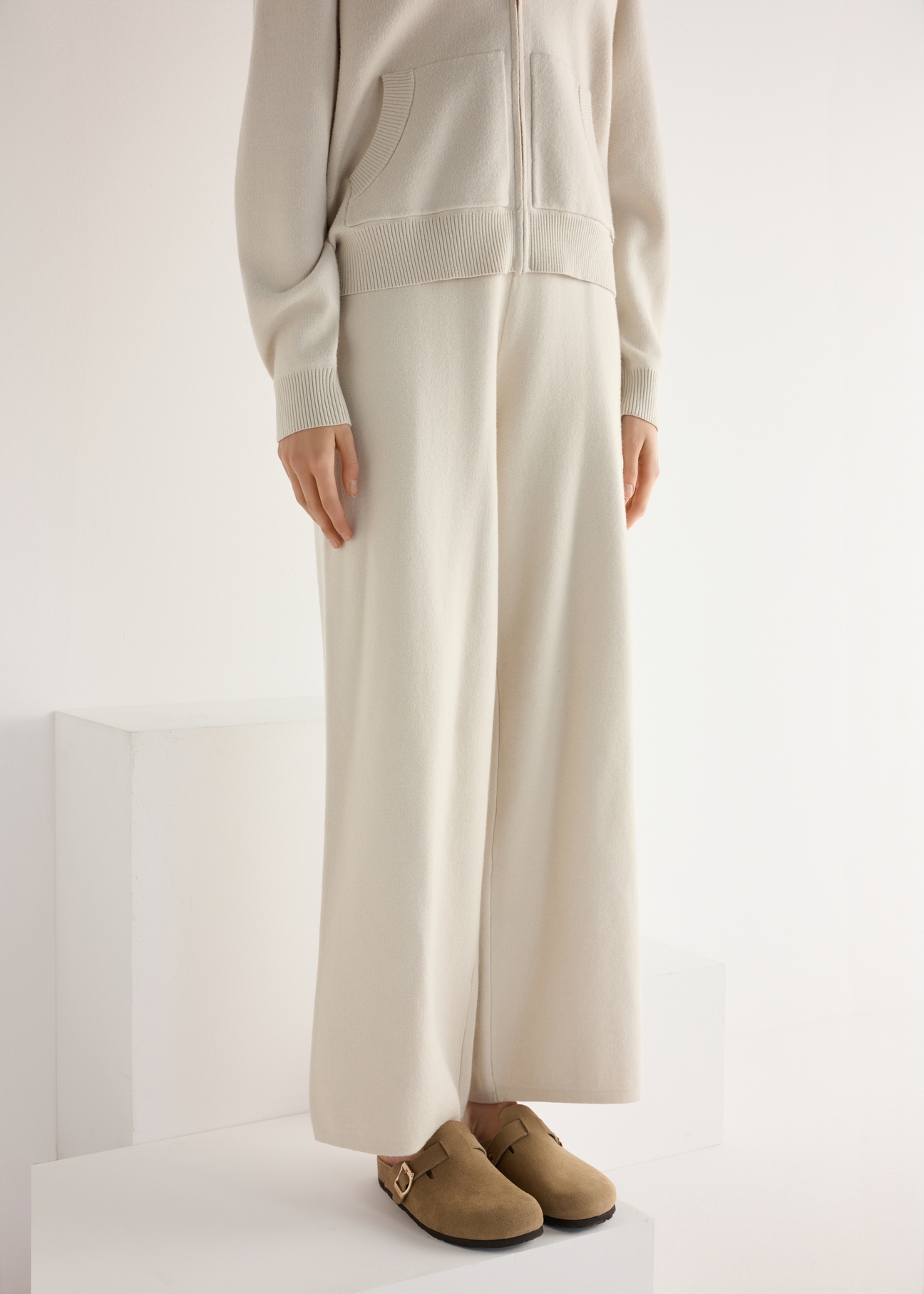 Жіночі замшеві шльопанці холодного бежевого кольору BUTYD-1267-1K(W26), діагональний вигляд виробу на ногах моделі.