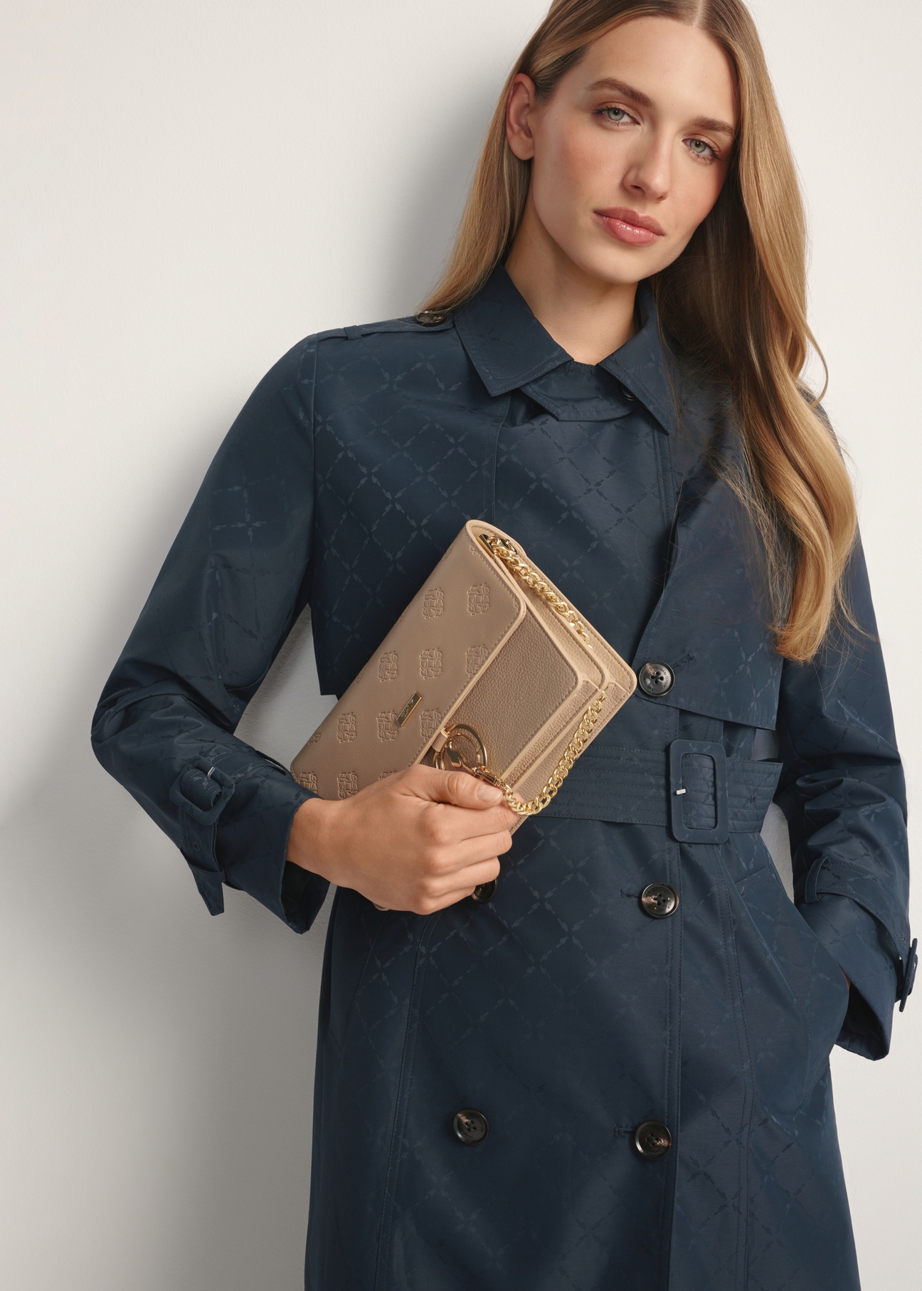 Бежева жіноча сумка з монограмою TOREC-0536-1P(W26), вигляд виробу в руці моделі. Видно половину силуету.