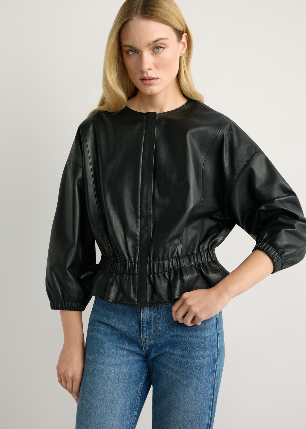 Жіноча чорна шкіряна куртка KURDS-0570-99(W26), вигляд виробу спереду на моделі. Видно половину силуету.