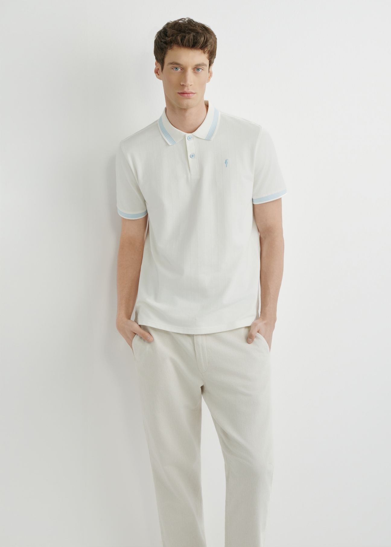 Біла сорочка-поло POLMT-0090-0B(W26), вигляд виробу спереду на моделі. Видно половину силуету.