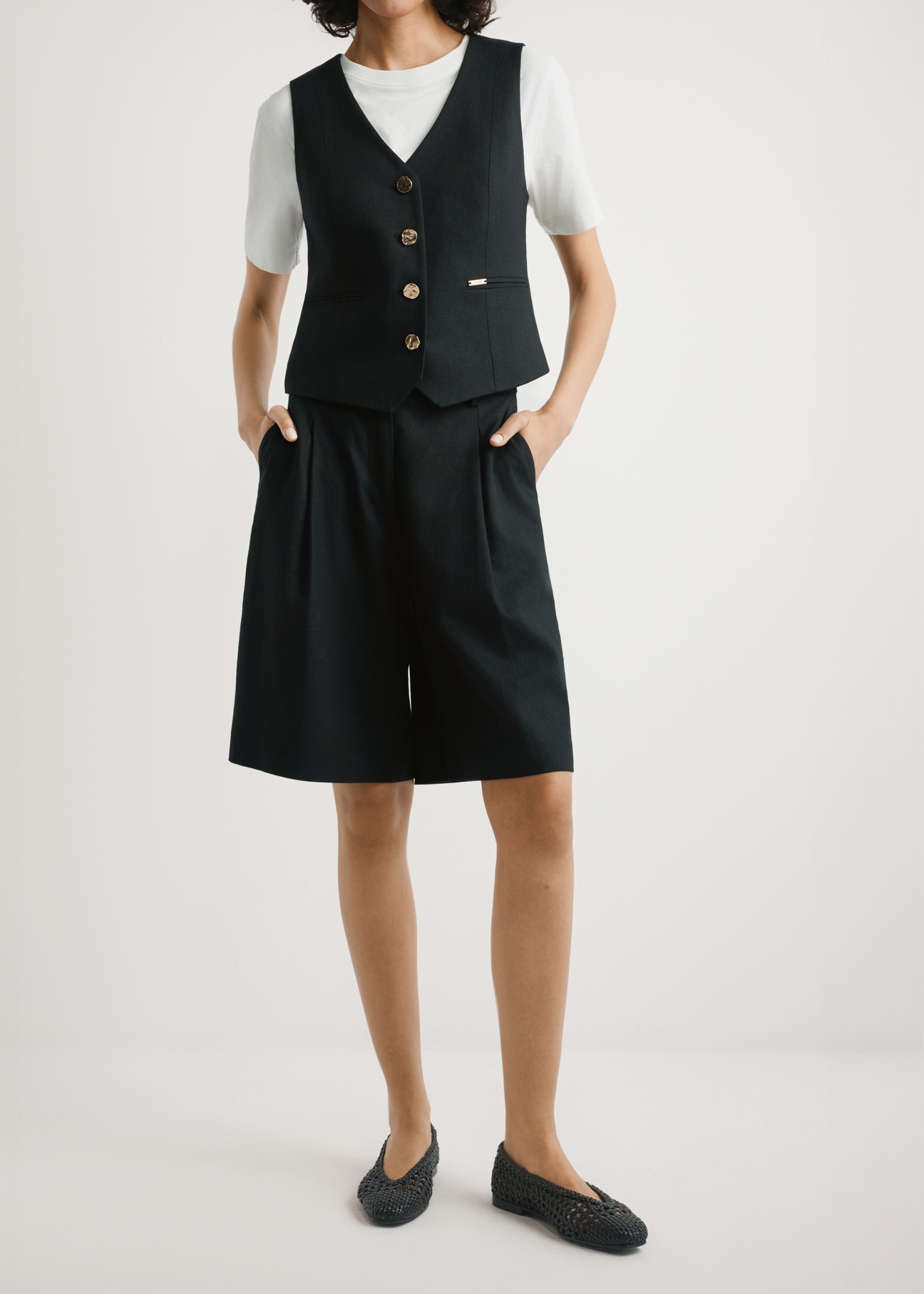 Жіночі елегантні чорні шорти SZODT-0017-99(W26), вигляд виробу спереду на моделі. Видно половину силуету.