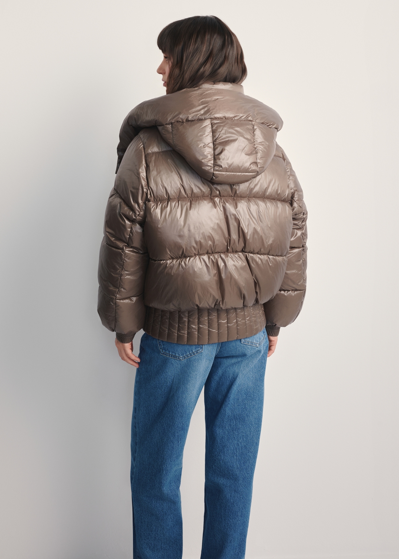Жіноча коротка коричнева куртка KURDT-0608-82(Z25), вигляд виробу ззаду на моделі. Видно половину силуету.