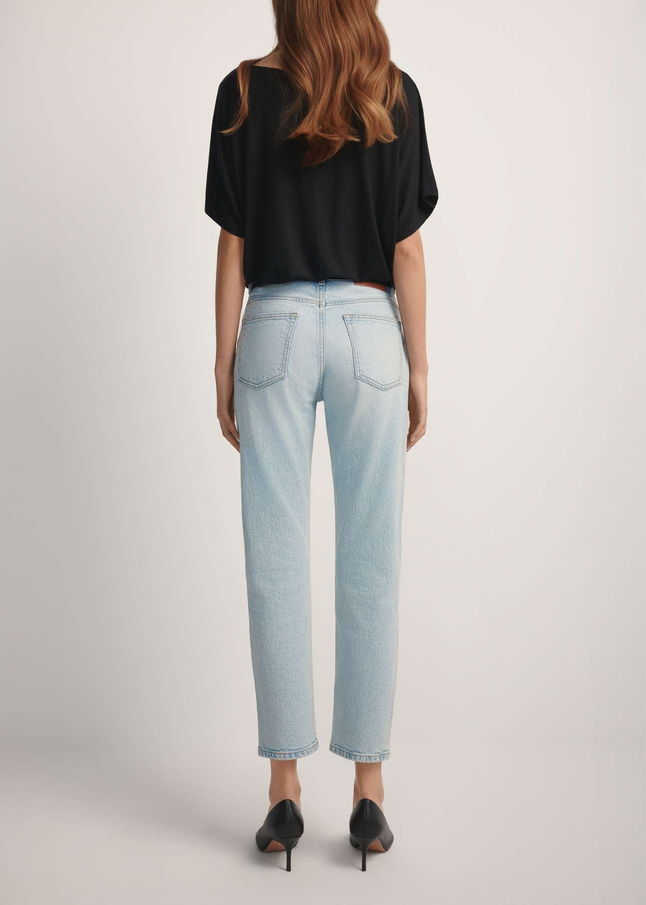 Світло-блакитні жіночі джинси JEADT-0011-7A(W26), вигляд виробу ззаду на моделі. Видно половину силуету.