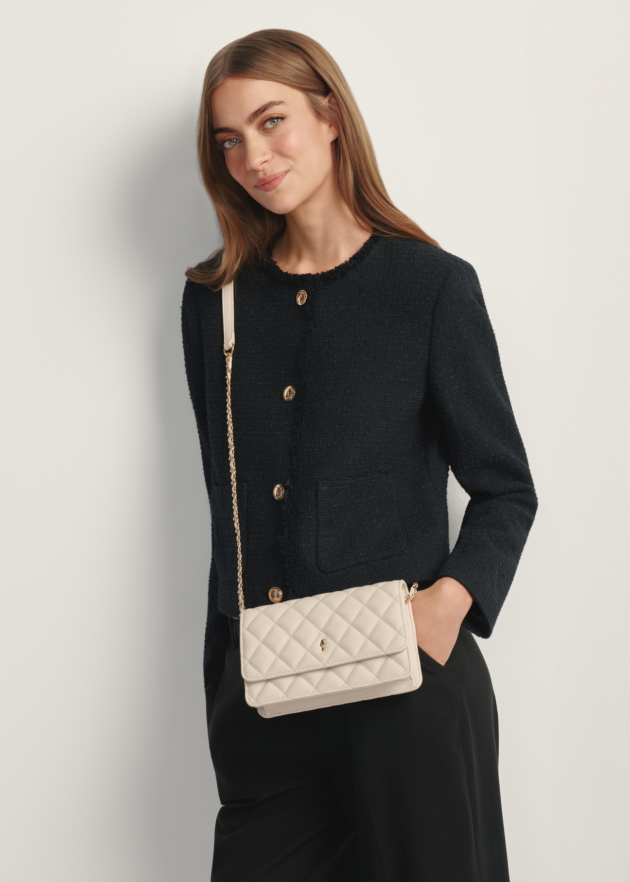 Кремова маленька стьобана жіноча сумочка TOREC-1033-0B(W26), вигляд виробу на плечі моделі. Видно половину силуету.