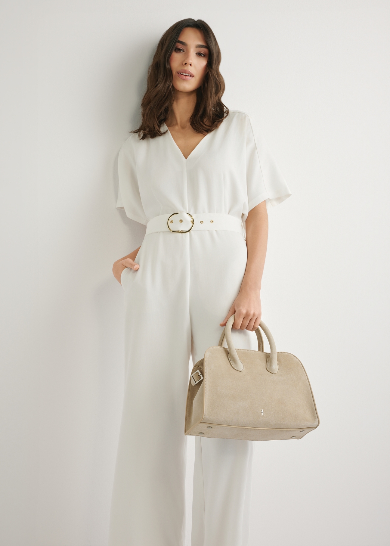 Кремова замшева жіноча сумка TORES-1295-0B(W26), вигляд виробу в руці моделі. Видно половину силуету.