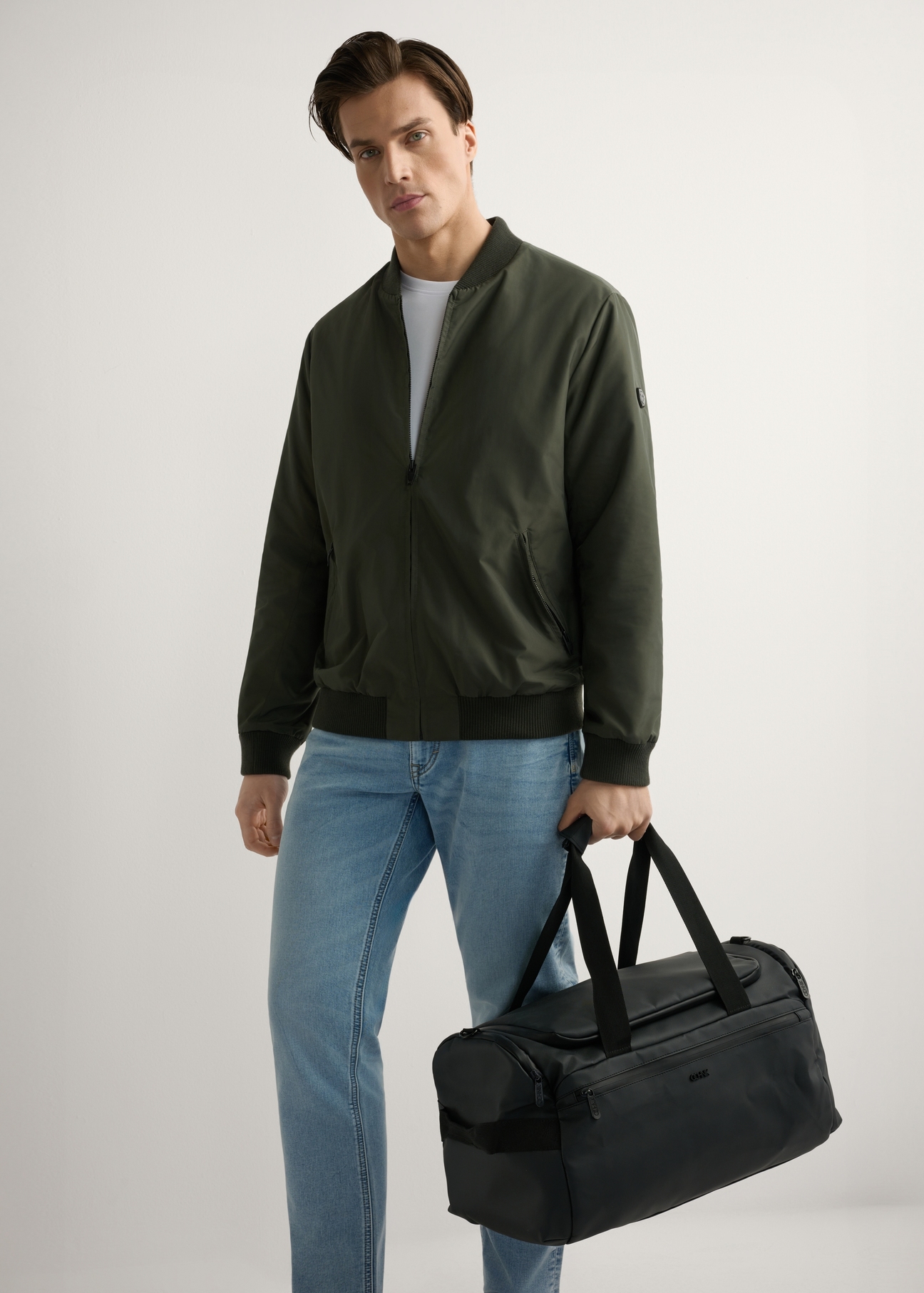 Чорна дорожня сумка TORMN-0412-99(W26), вигляд виробу в руці моделі. Видно повністю.