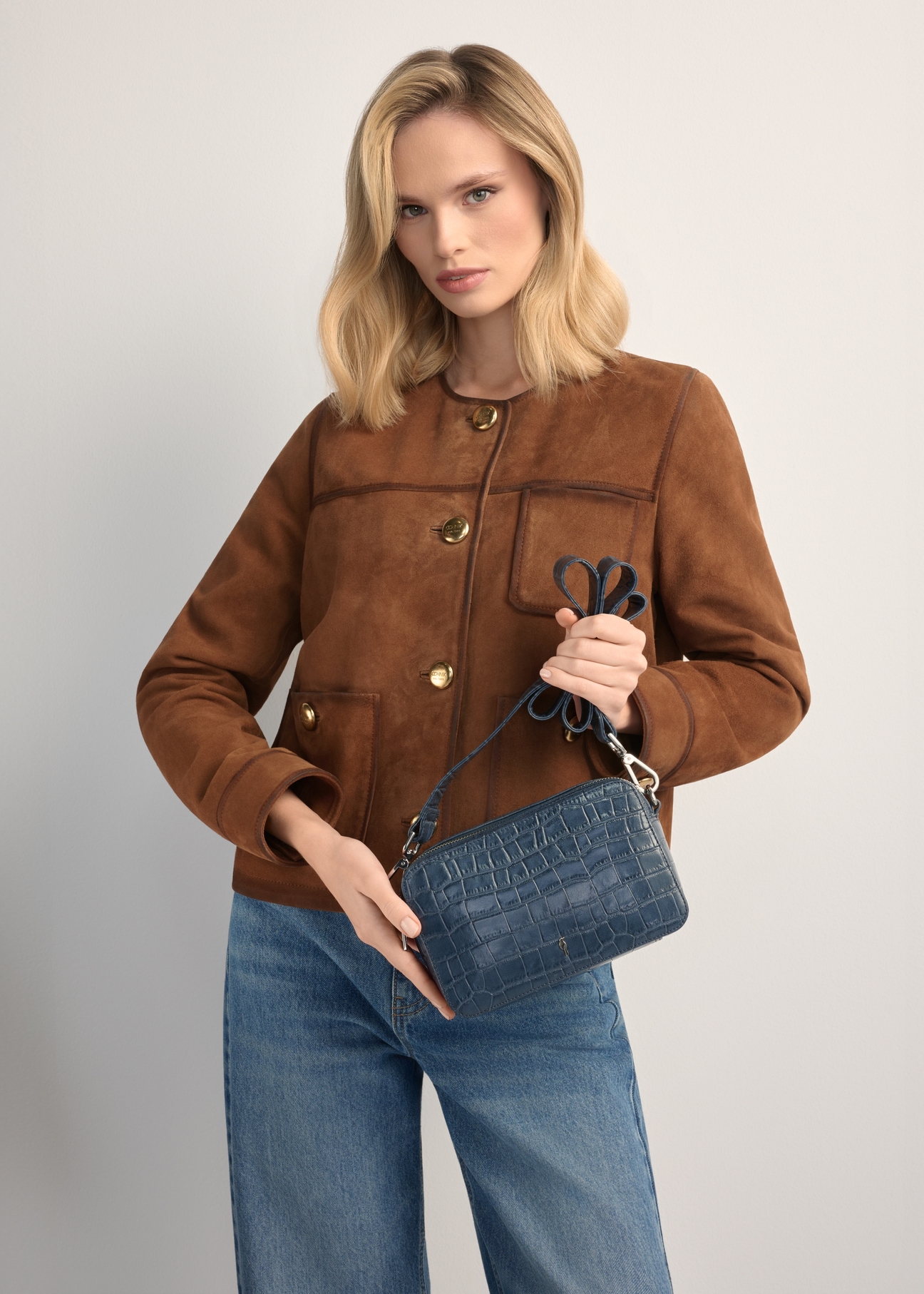 Маленька темно-синя сумочка зі шкіри під крокодила TORES-1231-7D(W26), вигляд виробу в руках моделі. Видно половину силуету.