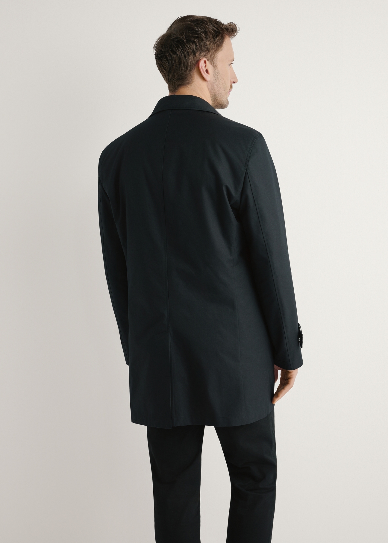 Чоловіча чорна утеплена куртка KURMT-0408-99(W26), вигляд виробу зі спини на моделі. Видно половину силуету.